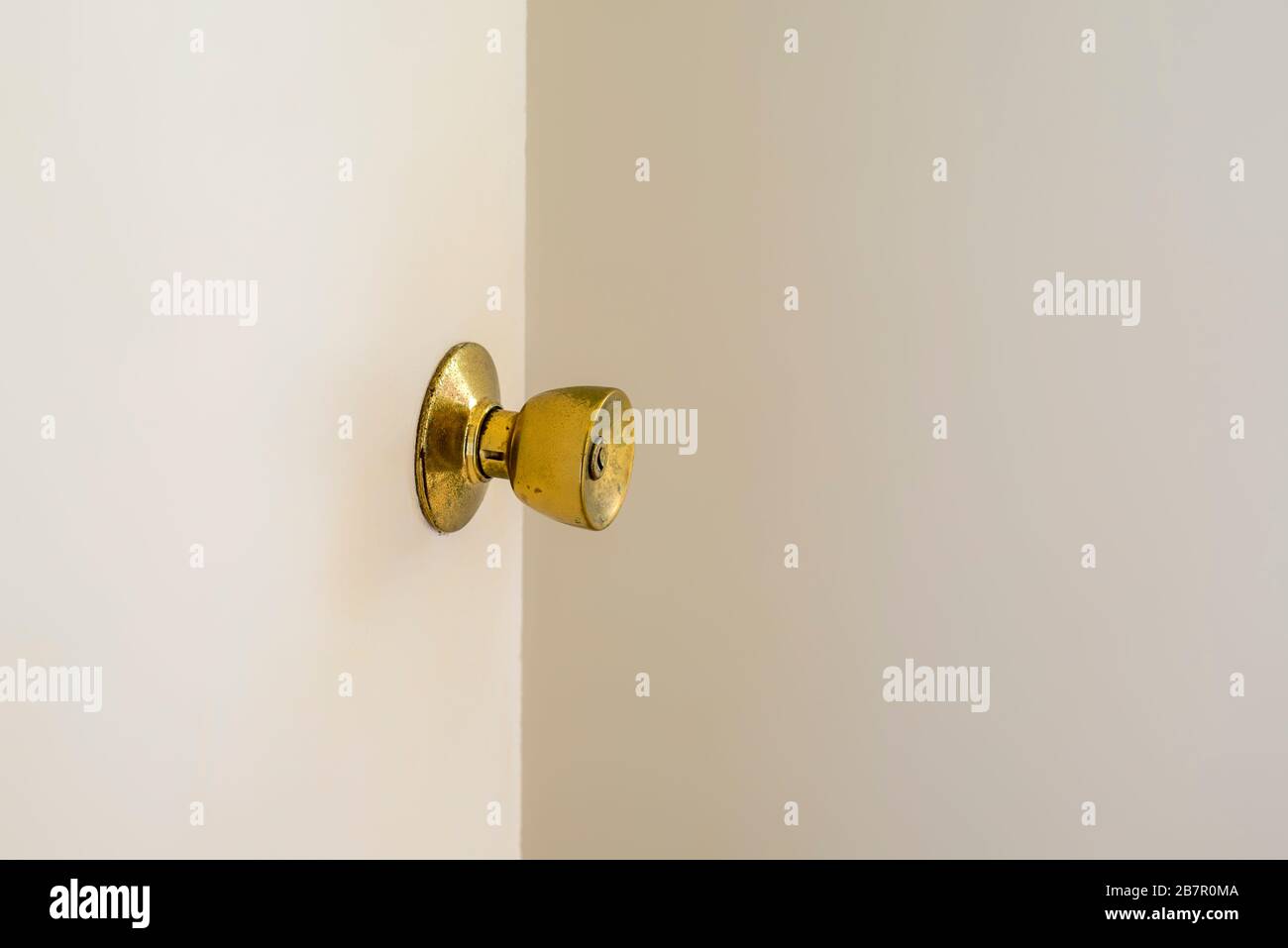 Una porta aperta con pomello di colore dorato in una casa. Foto Stock