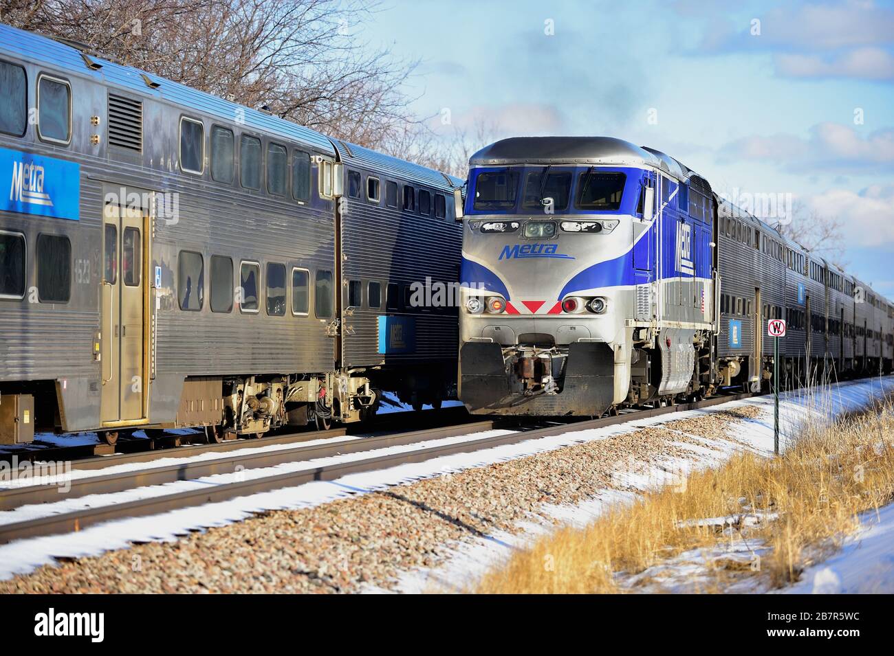 Bartlett, Illinois, Stati Uniti. I treni pendolari Metra passano a Bartlett, Illinois, in un pomeriggio invernale soleggiato ma freddo. Foto Stock