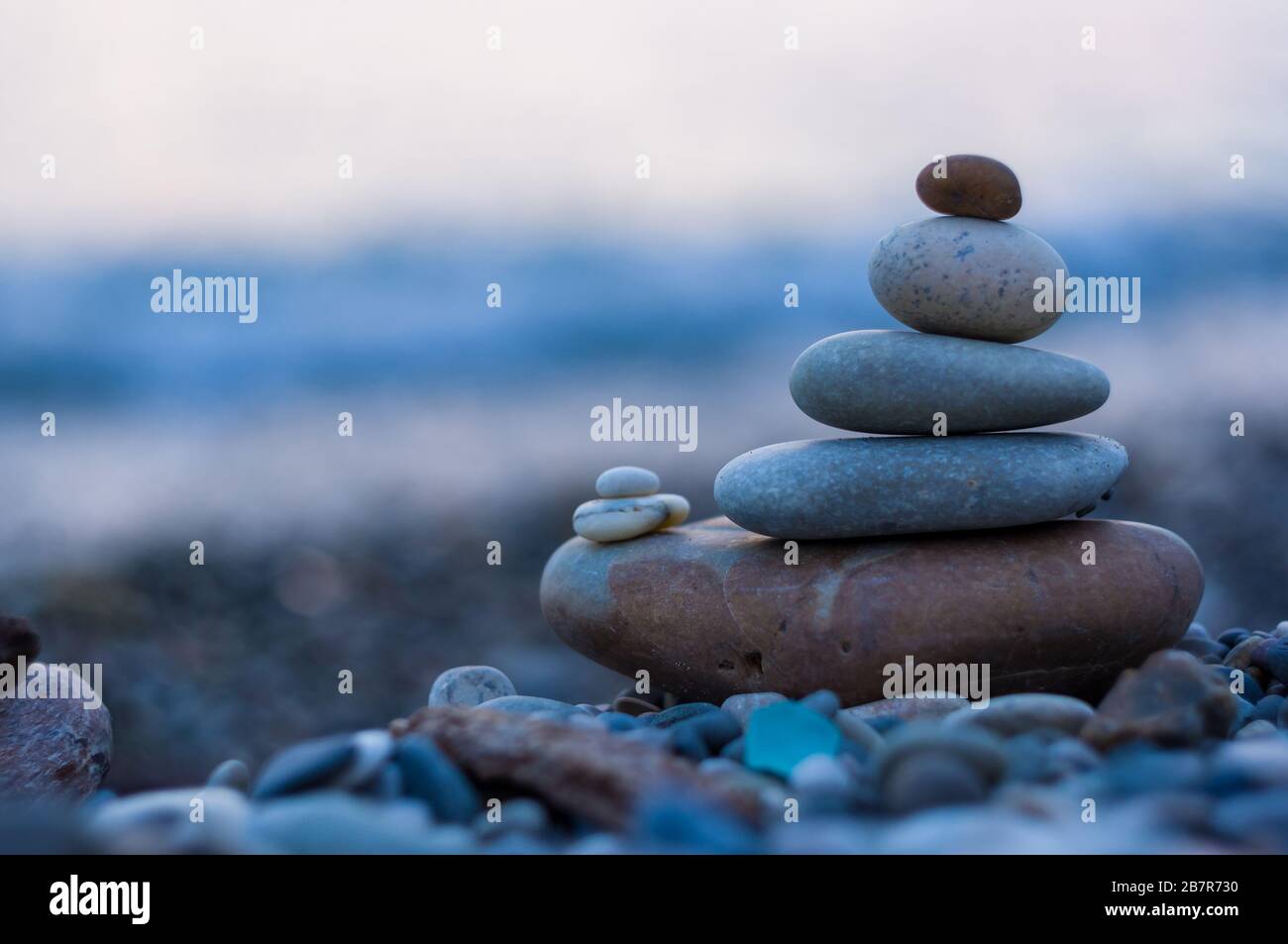 Pila di pietre zen sulla spiaggia ghiaiosa Foto Stock