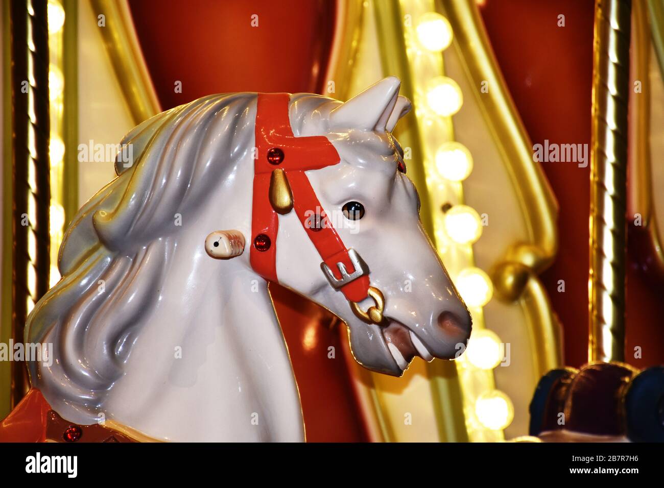 Giostra cavallo colorato primo piano con luci, bellissimo cavallo bianco Foto Stock