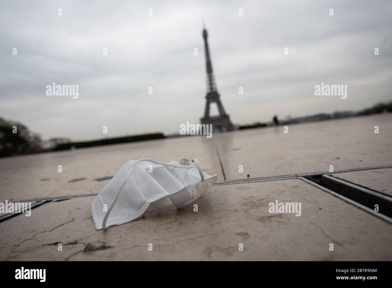 (200318) -- PARIGI, 18 marzo 2020 (Xinhua) -- UNA maschera facciale è vista a terra vicino alla Torre Eiffel a Parigi, Francia, il 17 marzo 2020. La Francia ha rilevato 7,730 casi di infezione da coronavirus e 175 persone erano morte del virus, il direttore generale della sanità Jerome Salomon ha annunciato martedì ad un aggiornamento quotidiano. Nelle ultime 24 ore, altre 1,097 persone sono state diagnosticate con il COVID-19, che ha causato altre 27 morti. Martedì mezzogiorno la Francia è stata messa a posto per almeno 15 giorni. Sono consentiti solo viaggi realmente necessari, come per motivi professionali o sanitari o per acquistare alimenti. (Punto Foto Stock