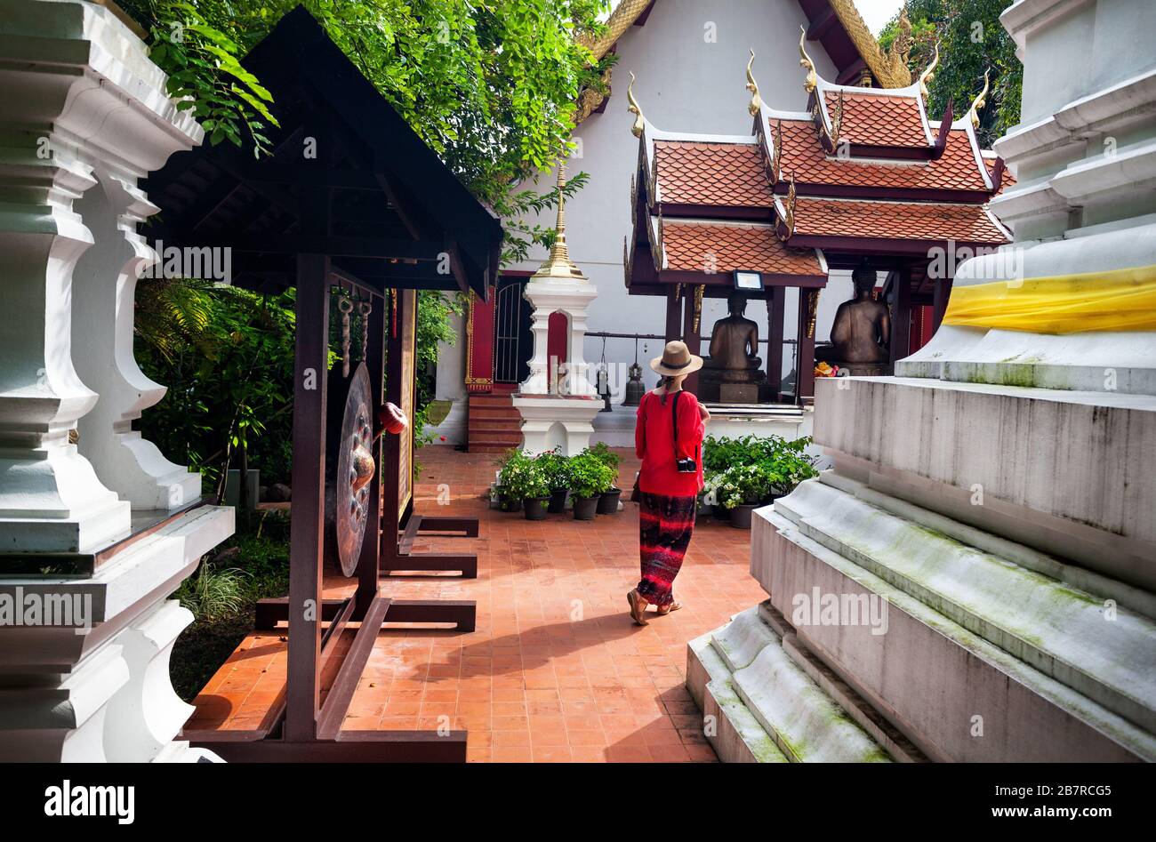 Donna Turistica in costume rosso che va al tempio nel Monastero di Wat Phra Kaew a Chiang Rai, Thailandia Foto Stock