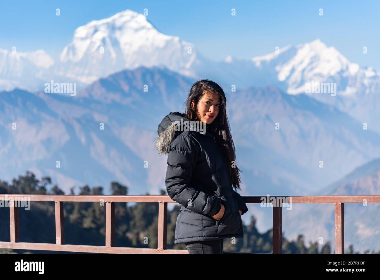 Bella ragazza in posa davanti alla catena montuosa di Dhaulagiri, Pokhara, Nepal Foto Stock