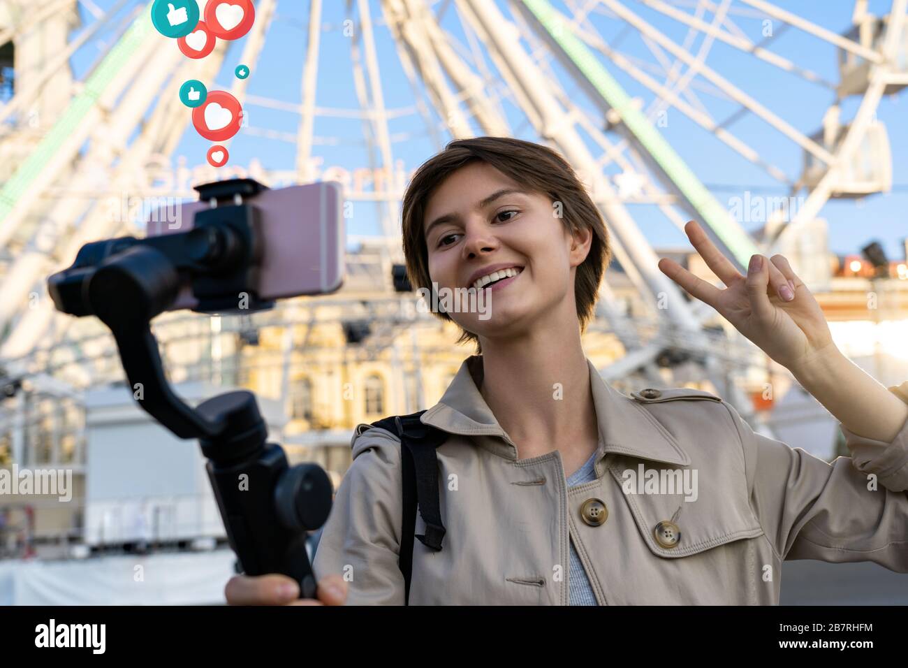 Ragazza blogger record viaggio vlog tenere telefono su selfie bastone ottenere piace. Foto Stock
