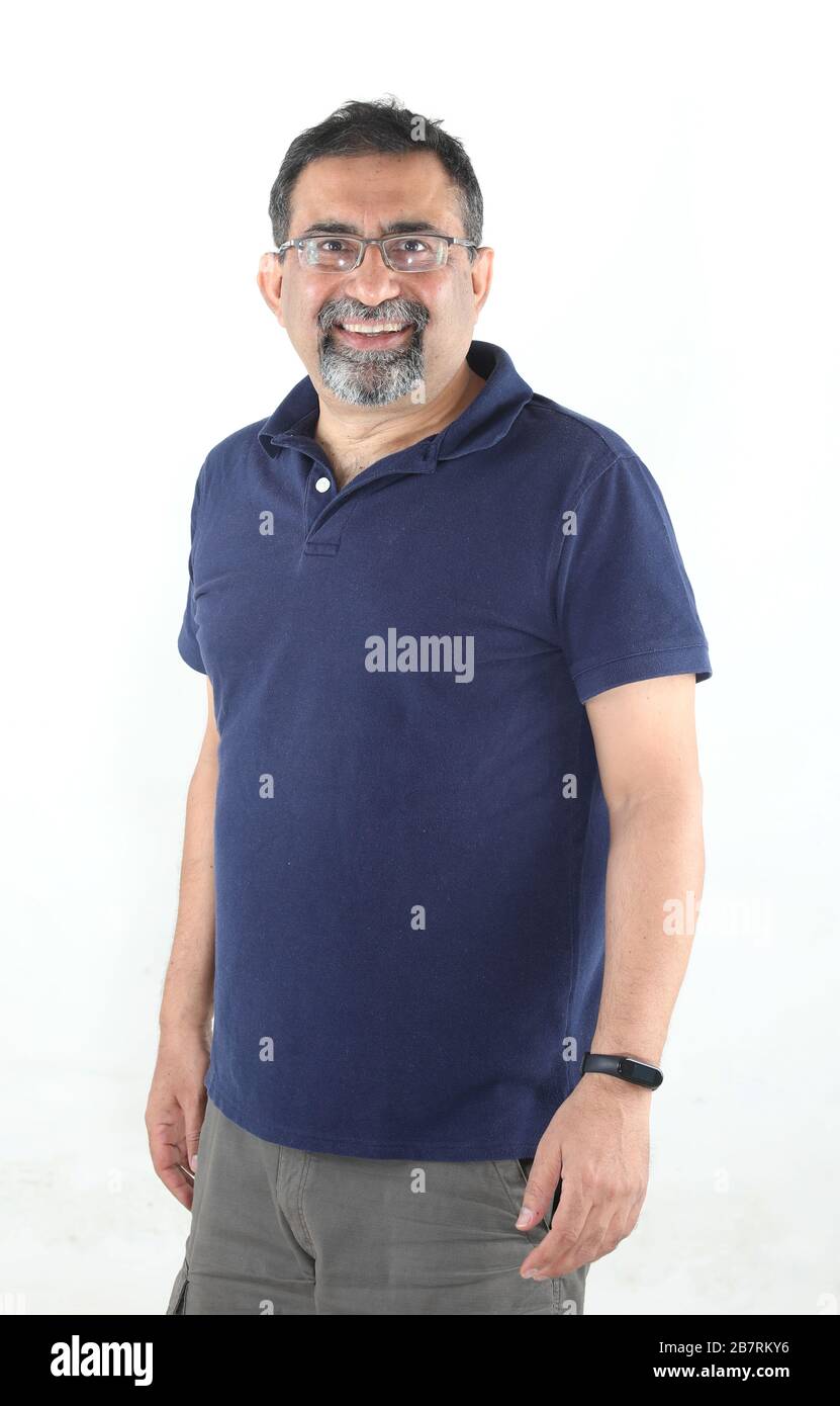 Un uomo indiano sorridente con un portiere in uno studio su sfondo bianco. Indossare occhiali e guardare la fotocamera. Foto Stock