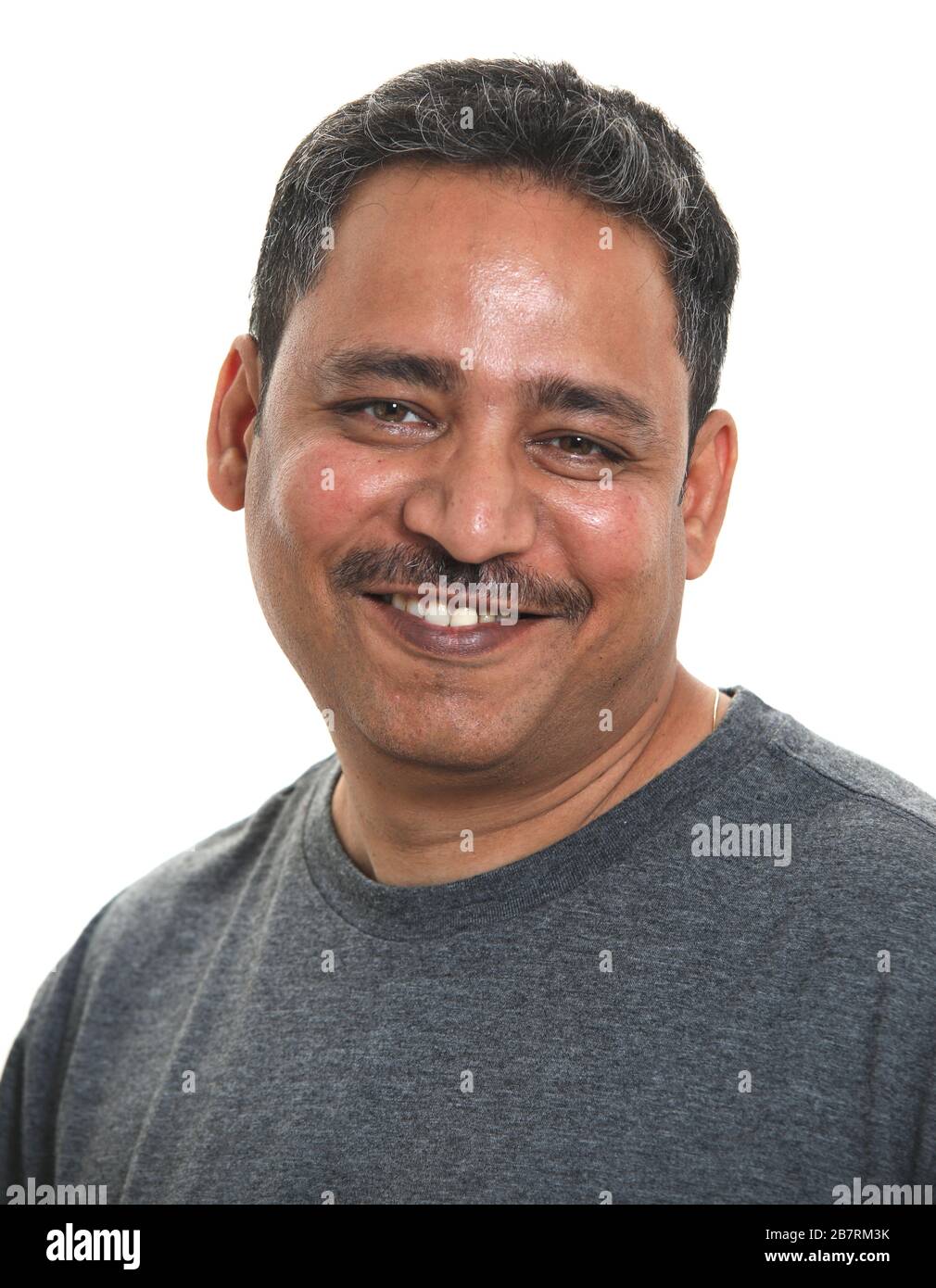 Un uomo indiano sorridente in uno studio su sfondo bianco Foto Stock