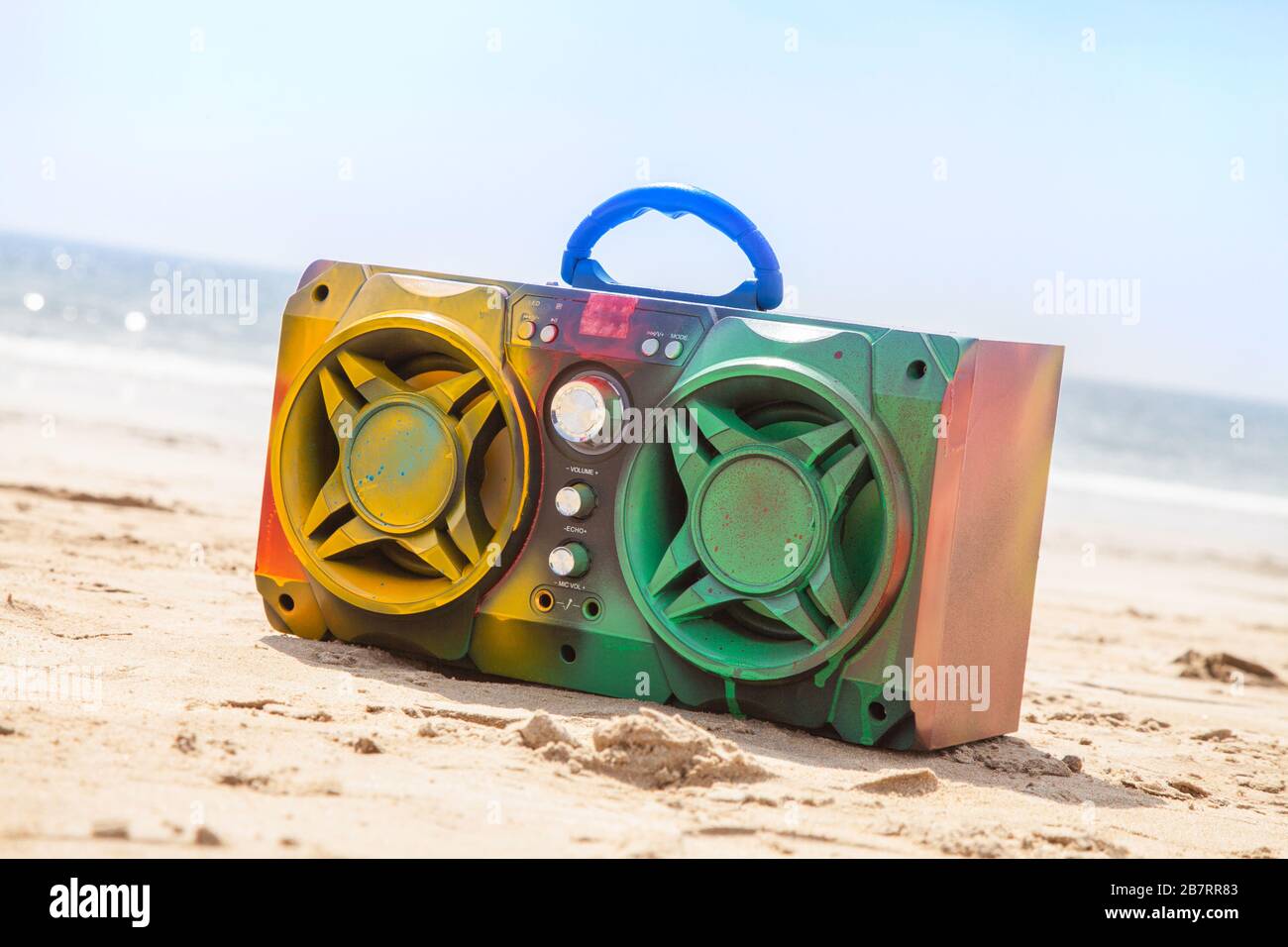 Scatola portamicrofono multicolore in vernice spray su sfondo spiaggia Foto Stock