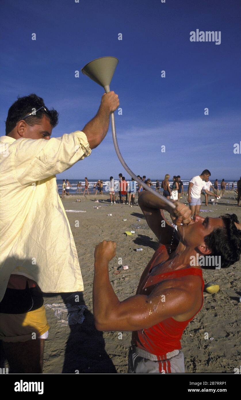 South Padre Island Texas USA: Studenti universitari maschili bevono da un boccale di birra sulla spiaggia durante la pausa primaverile. ©Bob Daemmrich Foto Stock