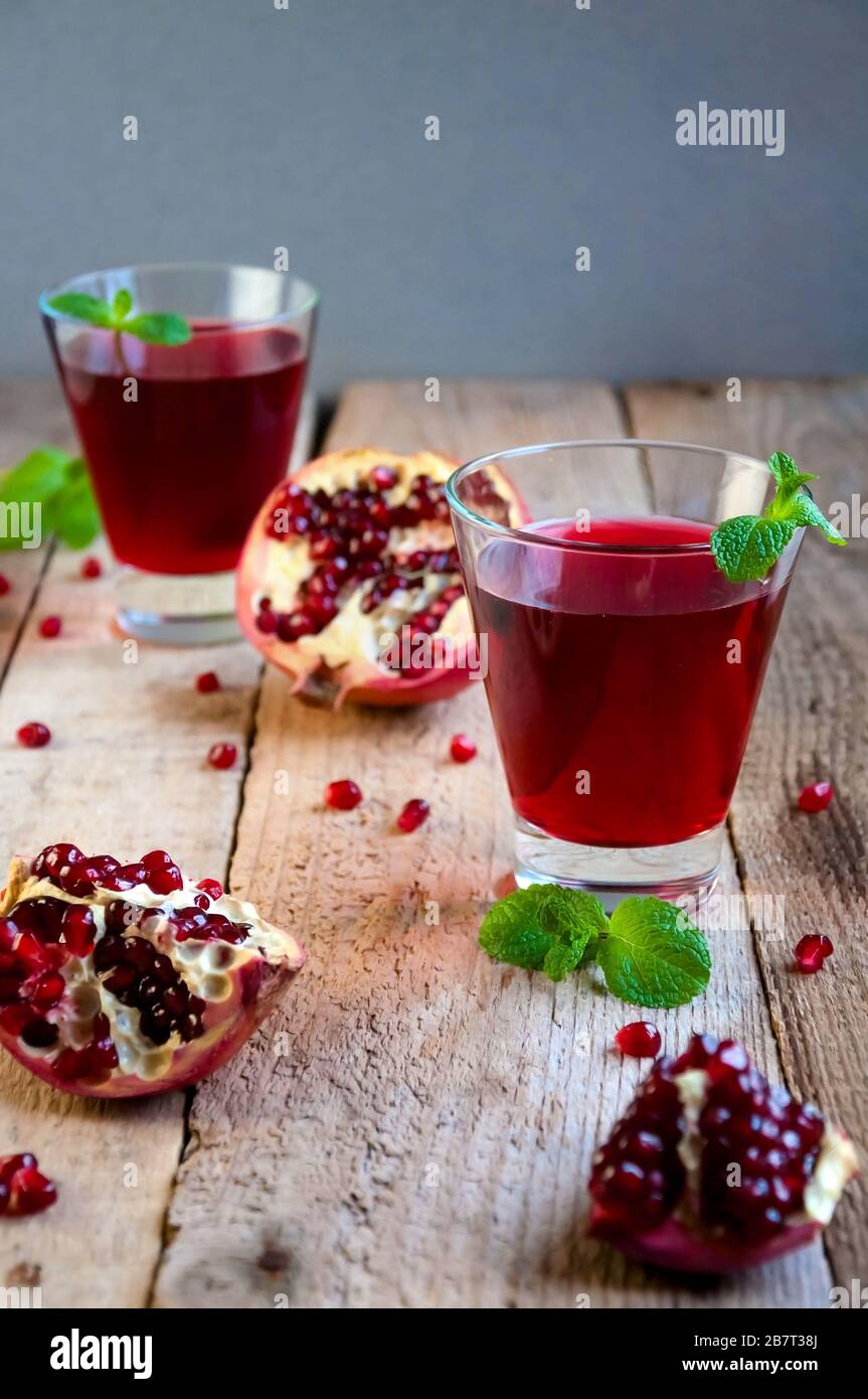 Cocktail di melograno con menta e frutta su tavolo di legno. Bevanda estiva rinfrescante, analcolica o alcolica. Foto Stock