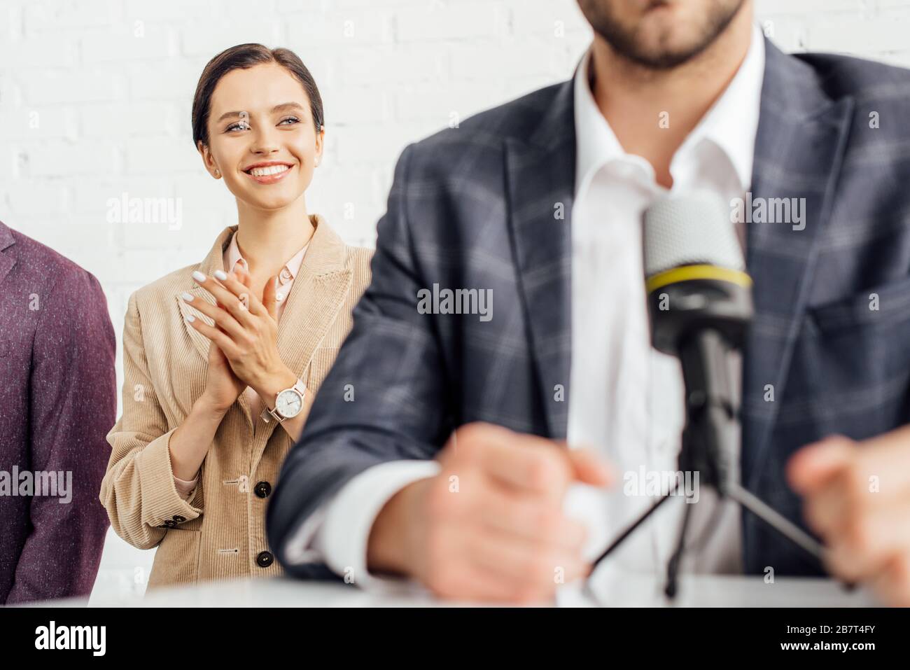 obiettivo selettivo di attraente donna d'affari in abbigliamento formale applapping in sala conferenze Foto Stock