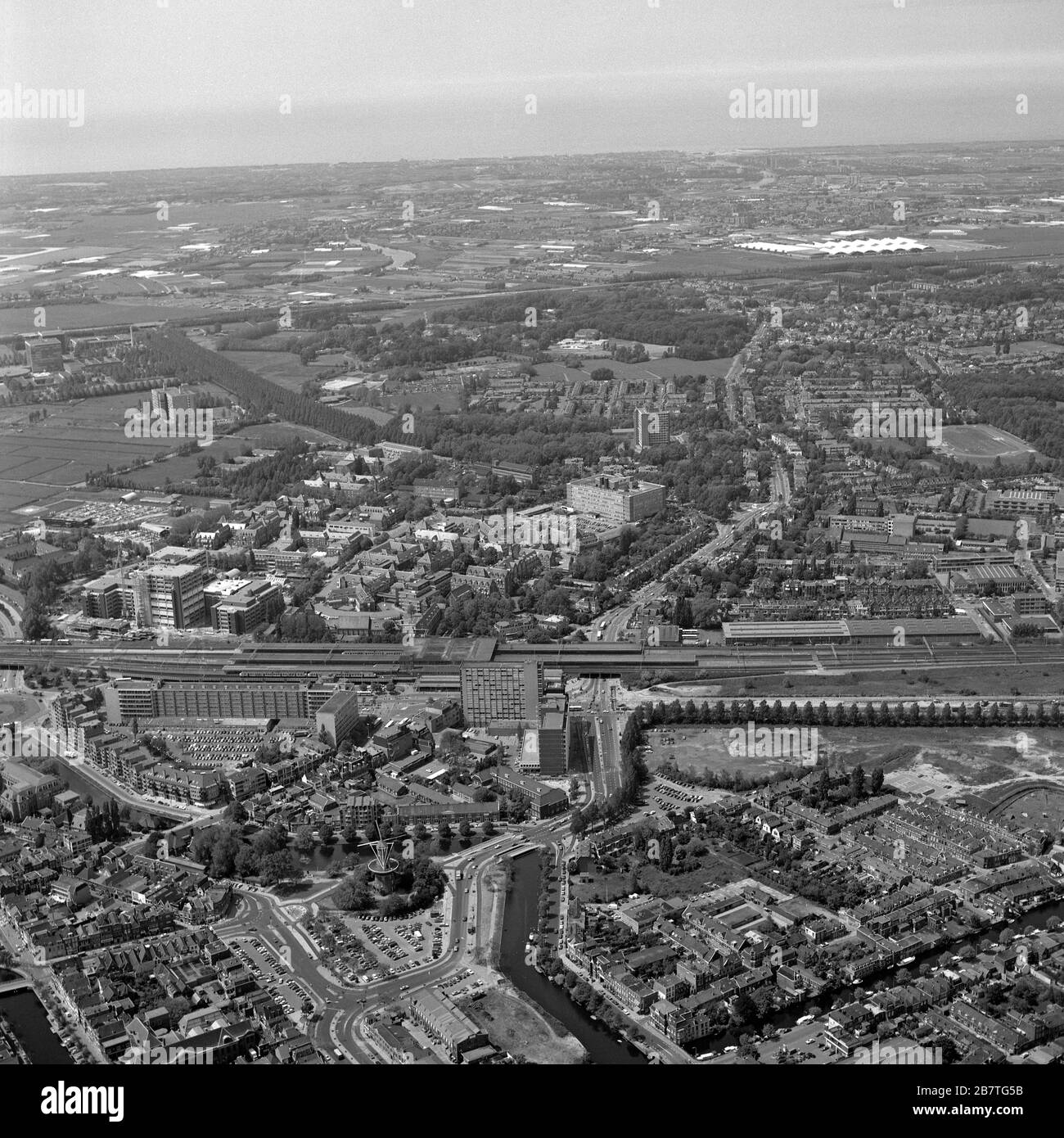 Leiden, Olanda, 03 giugno - 1983: Foto aerea storica in bianco e nero del quartiere della Stazione di Leiden e della stazione ferroviaria Foto Stock