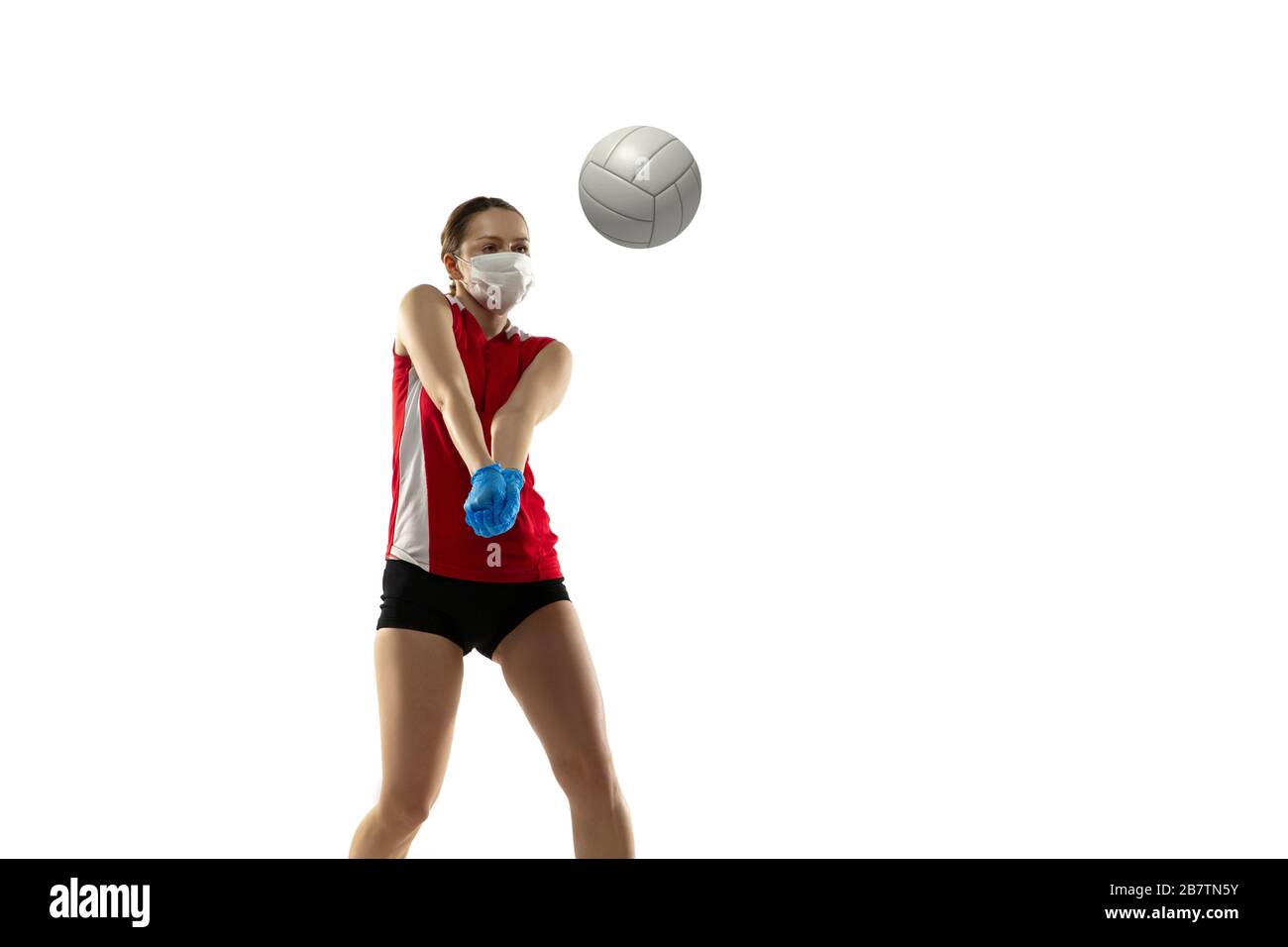 Vinci la disperazione. Giocatore di pallavolo in maschera protettiva e guanti. Prevenzione contro la polmonite. Ancora attivo durante la quarantena. Trattamento con coronavirus cinese. Concetto di salute, medicina, sport. Foto Stock