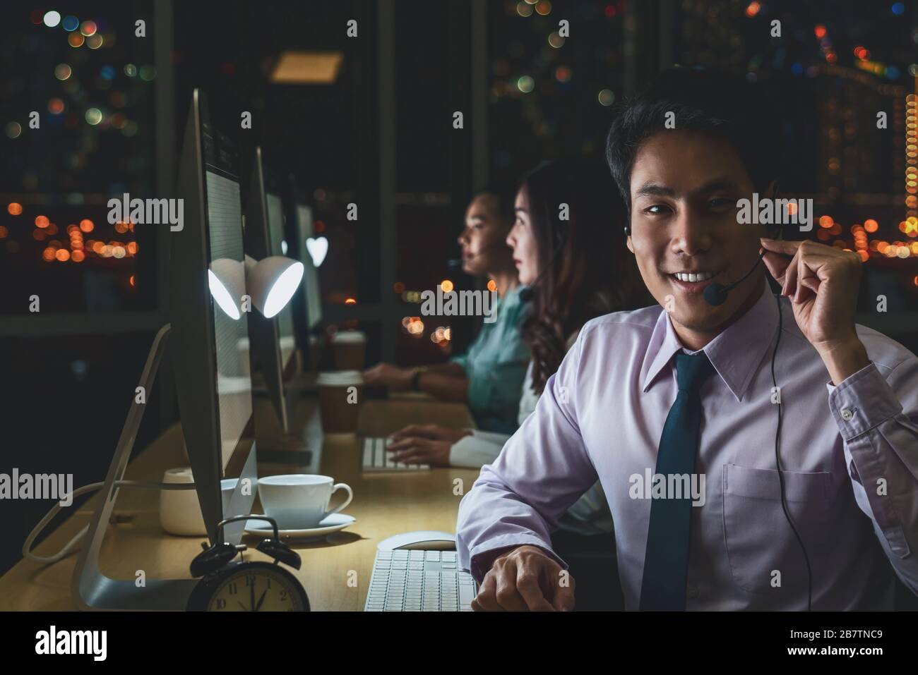 Ritratto del servizio di assistenza clienti maschile asiatico con donna d'affari sorridente e che lavora duro a tarda notte turno in ufficio, reparto call center, lavoratore A. Foto Stock Ritratto del servizio di assistenza clienti maschile asiatico con donna d'affari sorridente e che lavora duro a tarda notte turno in ufficio, reparto call center, lavoratore A. Foto Stock
