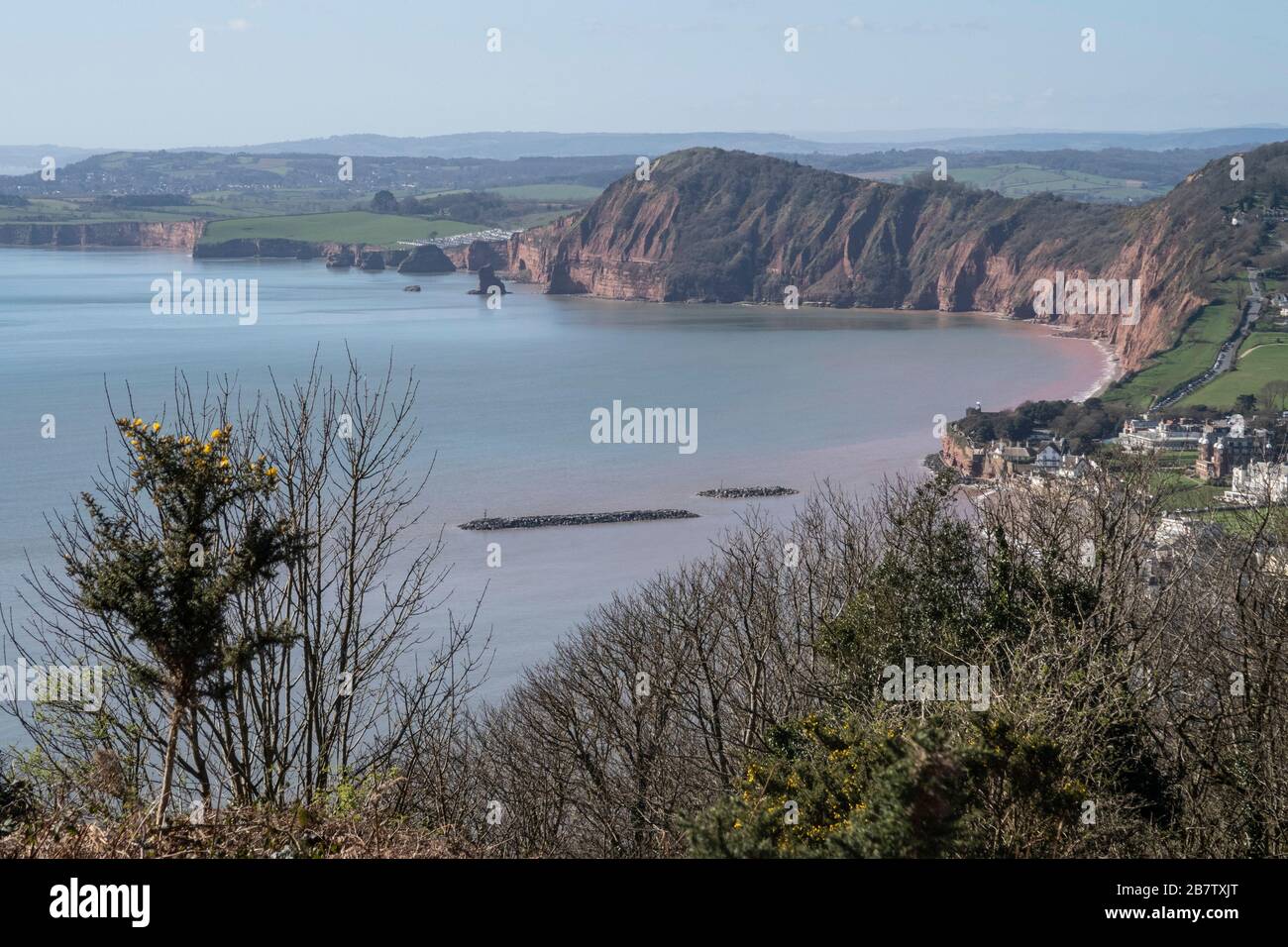 Vista sul lungomare di Sidmouth, Devon da Salcombe Hill, con grotte rocciose nel mare, e Peak Hill e High Peak in lontananza. Foto Stock