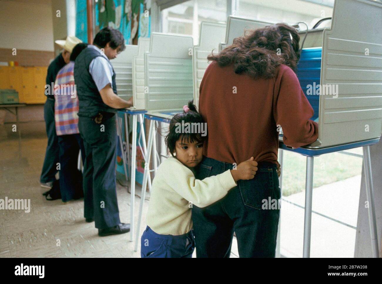 Austin, Texas USA: Il bambino si aggrappa alla madre, che sta votando nelle elezioni primarie. ©Bob Daemmrich Foto Stock