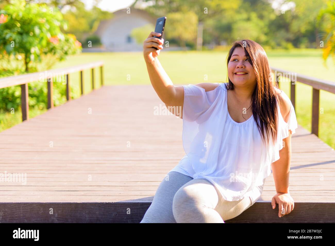 Bellissimo il sovrappeso donna asiatica di relax presso il parco Foto Stock