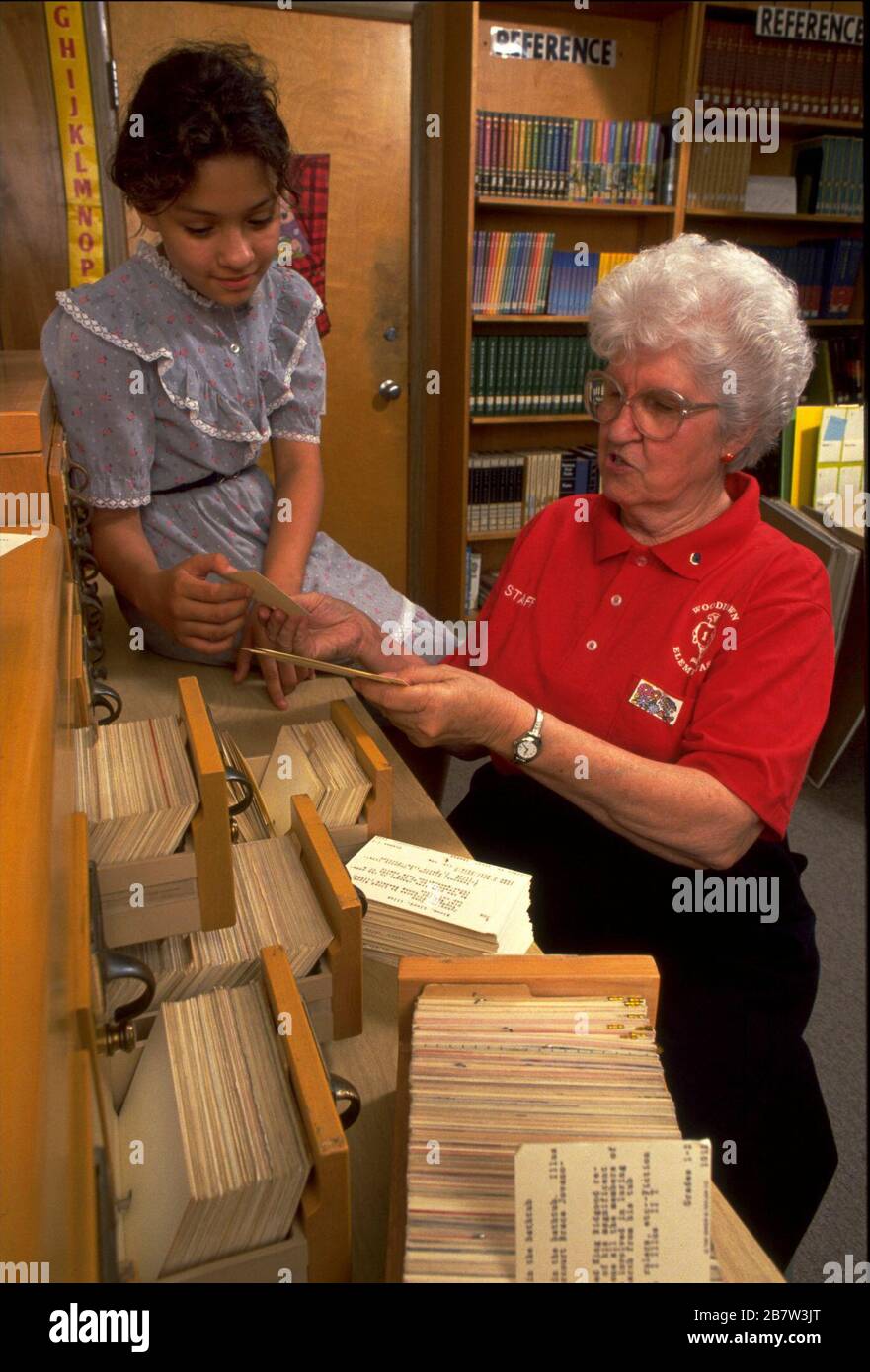 San Antonio, Texas USA: Lo studente aiuta la scuola bibliotecaria a refondare le carte nei cassetti del catalogo delle carte. SIGNOR ©Bob Daemmrich Foto Stock