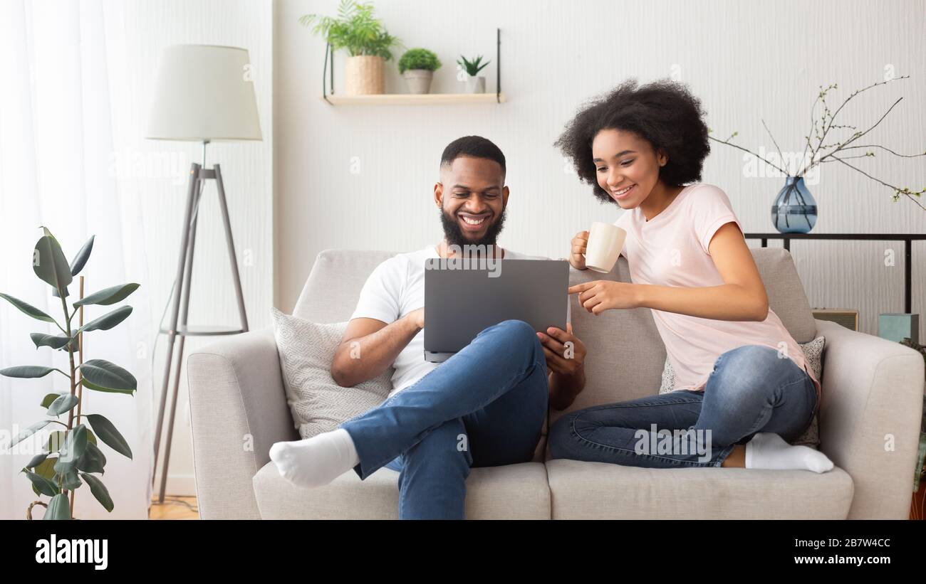 Coppia afro-americana sul divano con laptop Foto Stock