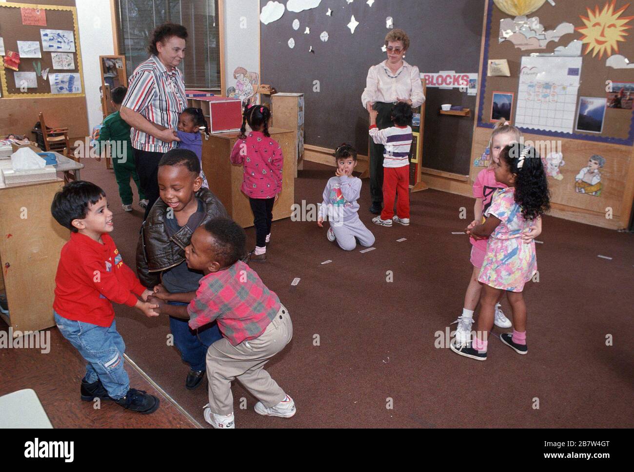 Gruppo diversificato di studenti pre-scuola che giocano il gioco di abilità con l'insegnante al programma Head Start. SIGNOR ©Bob Daemmrich Foto Stock