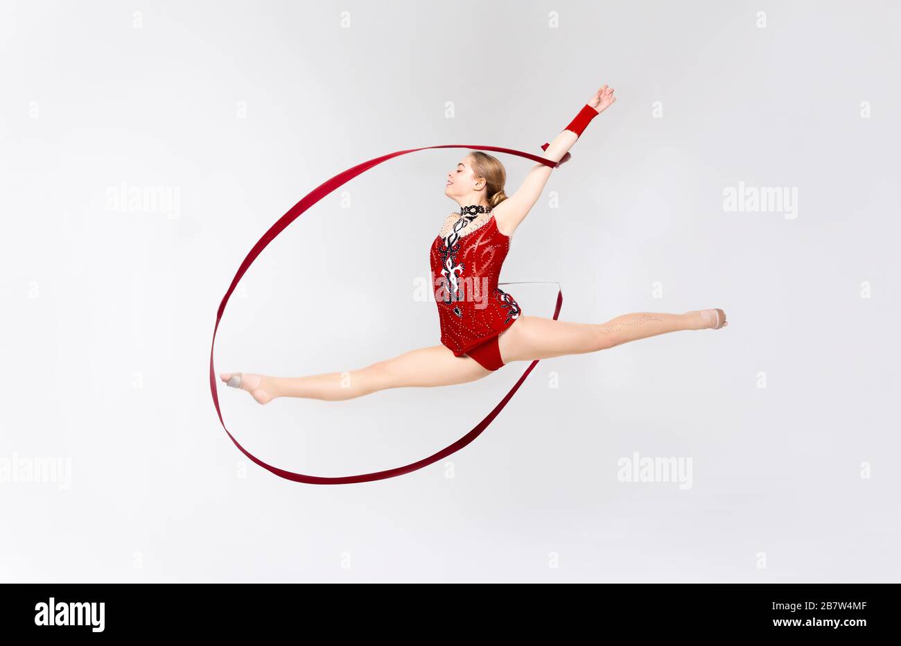 Affascinante ginnastica con corda che fa saltare in aria su sfondo bianco Foto Stock