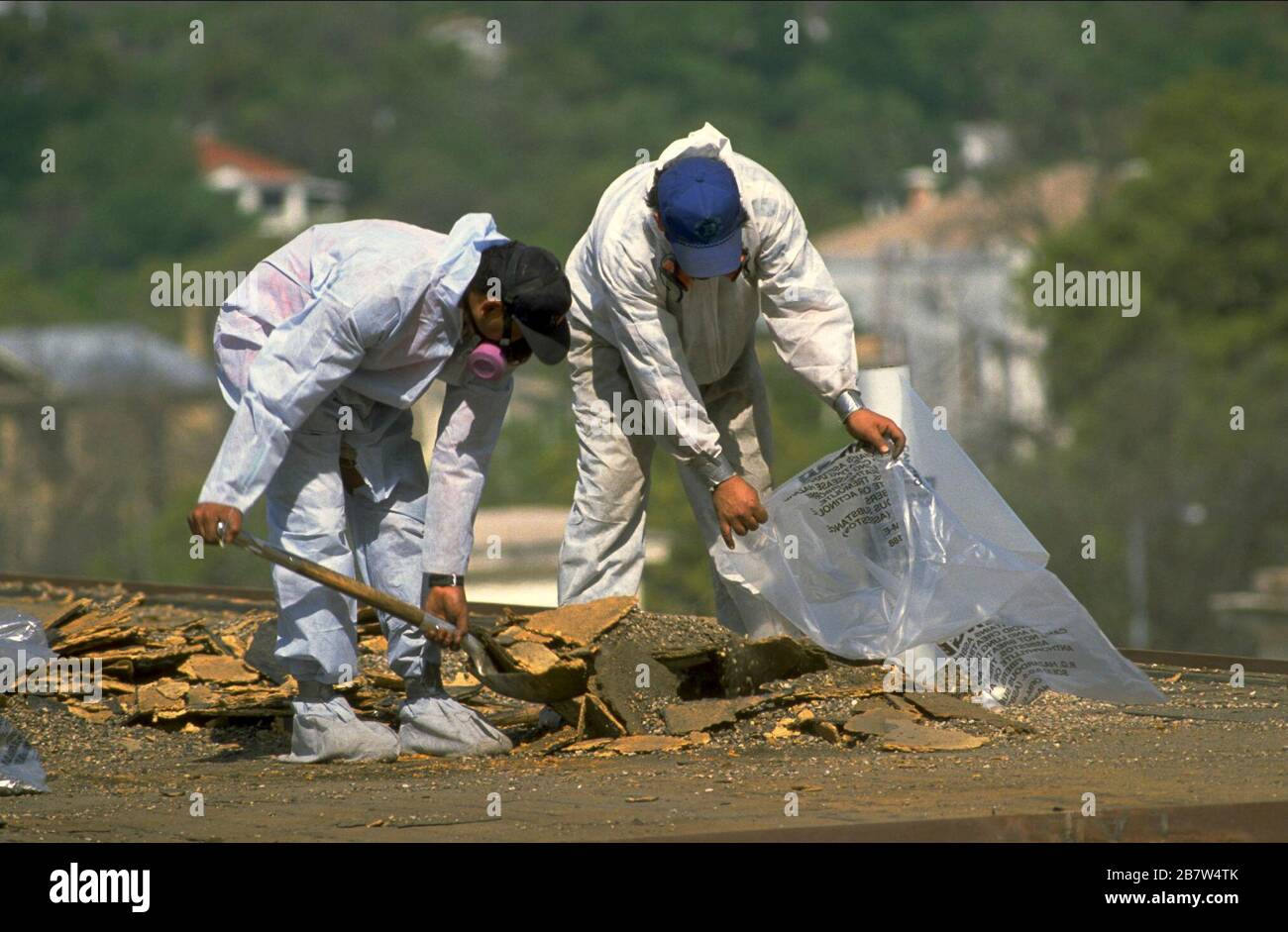 Austin, Texas USA: I lavoratori che indossano indumenti protettivi rimuovono l'amianto dal garage del parcheggio. ©Bob Daemmrich Foto Stock