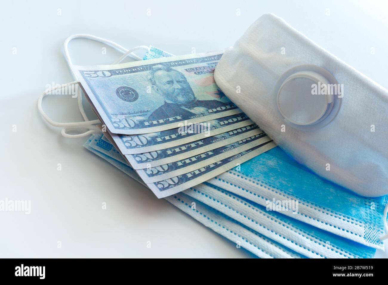 Maschere mediche e valuta americana. Concetto dell'impatto delle pandemie e delle malattie sugli scambi globali e sulla finanza. Foto Stock