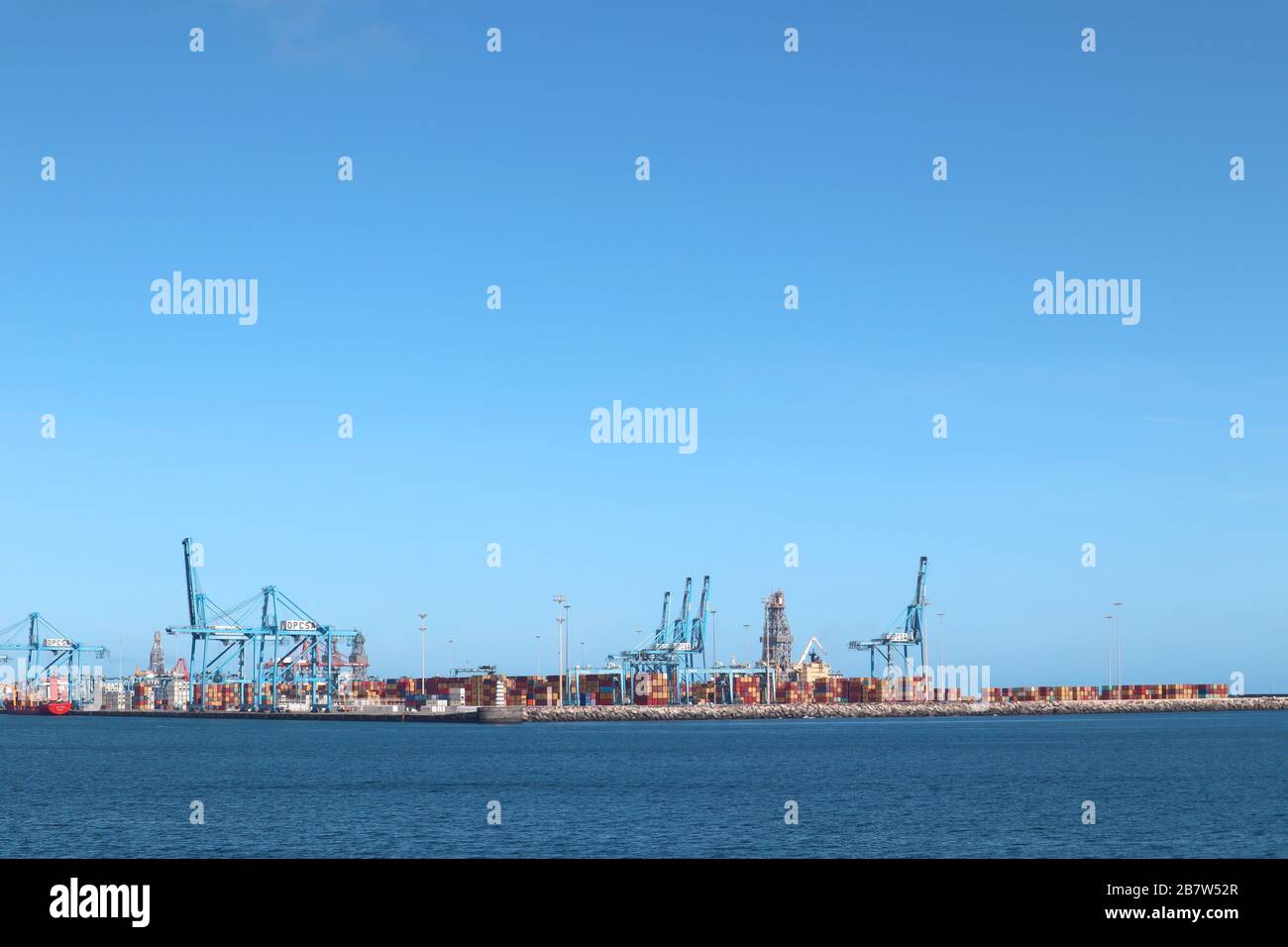 Porto commerciale con gru e container per l'esportazione e l'importazione di prodotti in una bella giornata Foto Stock