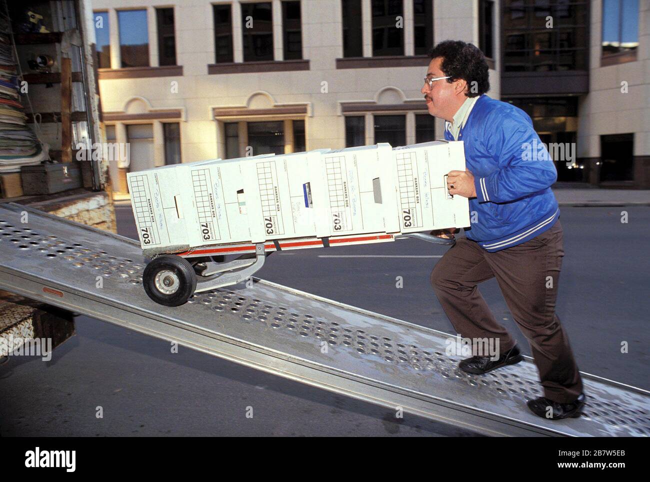 Austin, Texas USA: Il dipendente con un'azienda che si occupa di spostamento dell'ufficio spinge i record aziendali in box verso un furgone in movimento nel centro di Austin. SIGNOR ©Bob Daemmrich Foto Stock