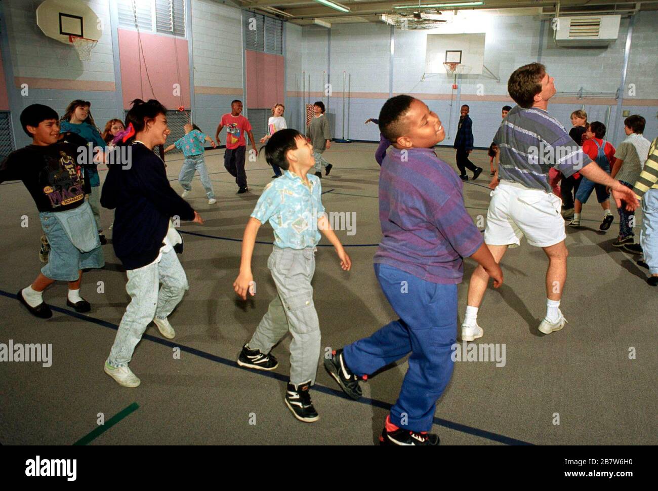 Austin, Texas USA: L'insegnante di educazione fisica conduce gli studenti nell'esercizio del movimento del corpo durante la lezione di P.E. in palestra scolastica. ©Bob Daemmrich Foto Stock