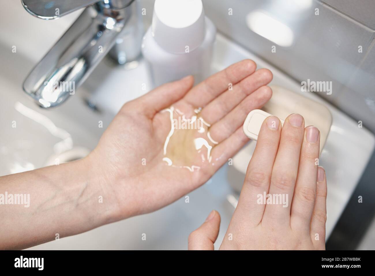 Pulizia delle mani con igienizzatore in bagno. Concetto di autoprotezione e igiene in condizioni epidemiche Foto Stock