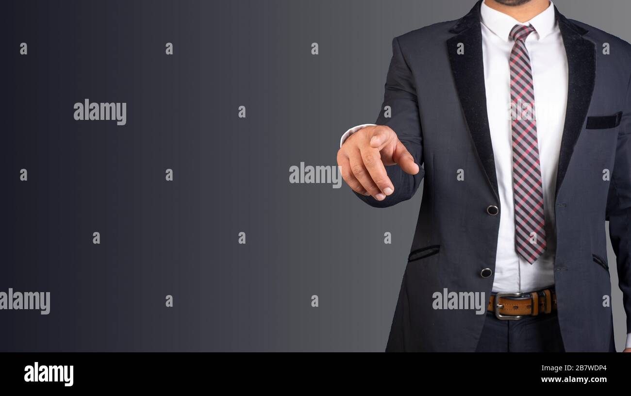 Uomo d'affari con tuta e cravatta che punta con il dito Foto Stock