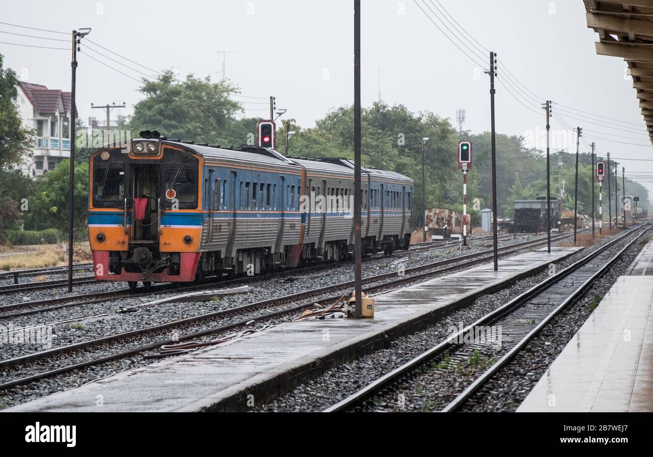 Le unità diesel multiple del treno locale partono dalla stazione urbana alla zona rurale in tempo di pioggia. Foto Stock