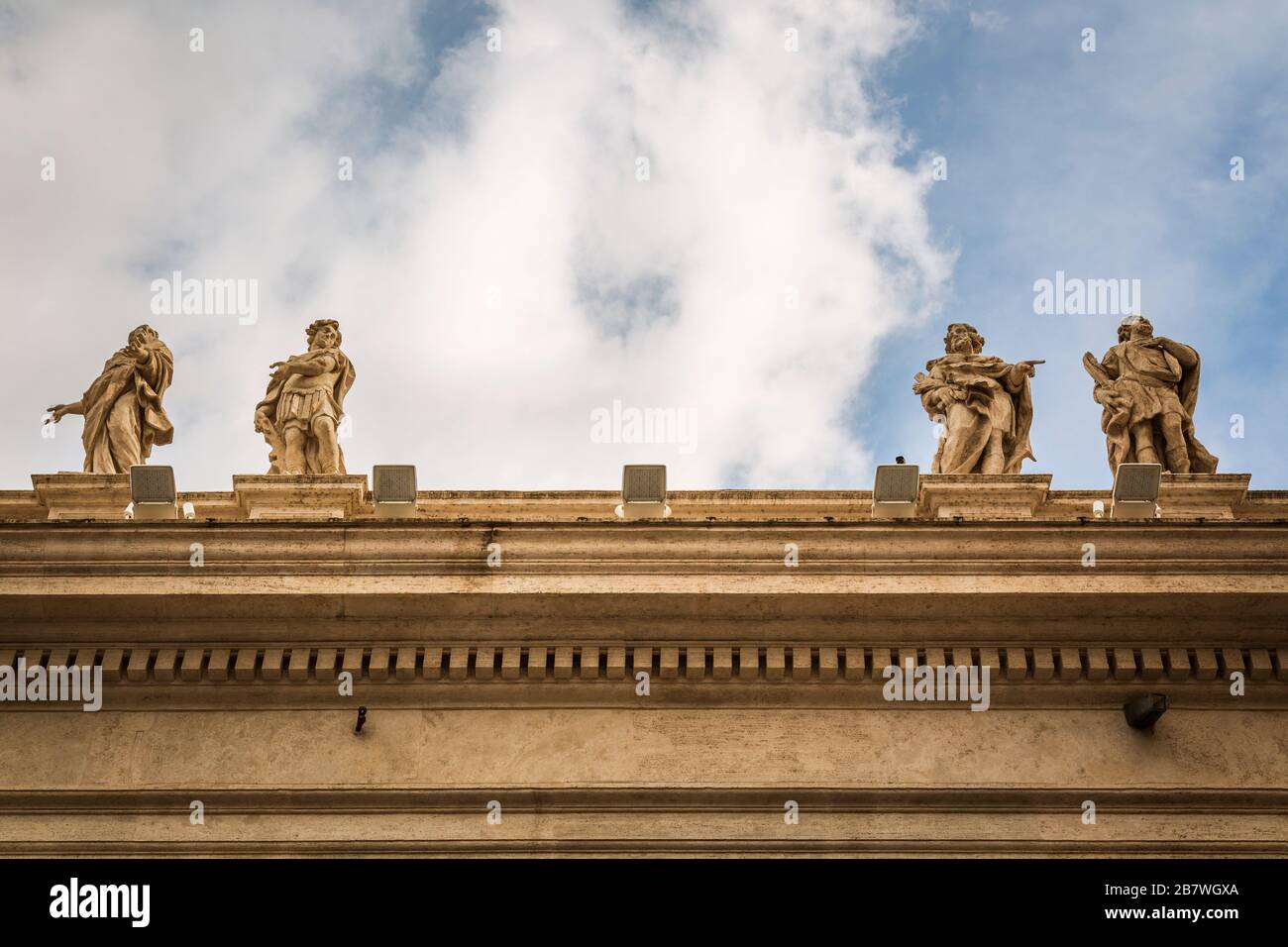 Particolare dei colonnati di Piazza San Pietro con statue di santi e il cielo sullo sfondo. Foto Stock