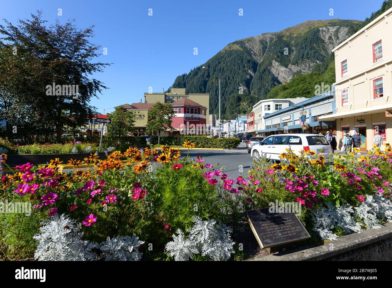 Vista di Juneau, Alaska Downtown con fiori sullo sfondo, Franklin Street con traffico auto e turisti. Giornata di sole in estate Alaska, USA. Foto Stock