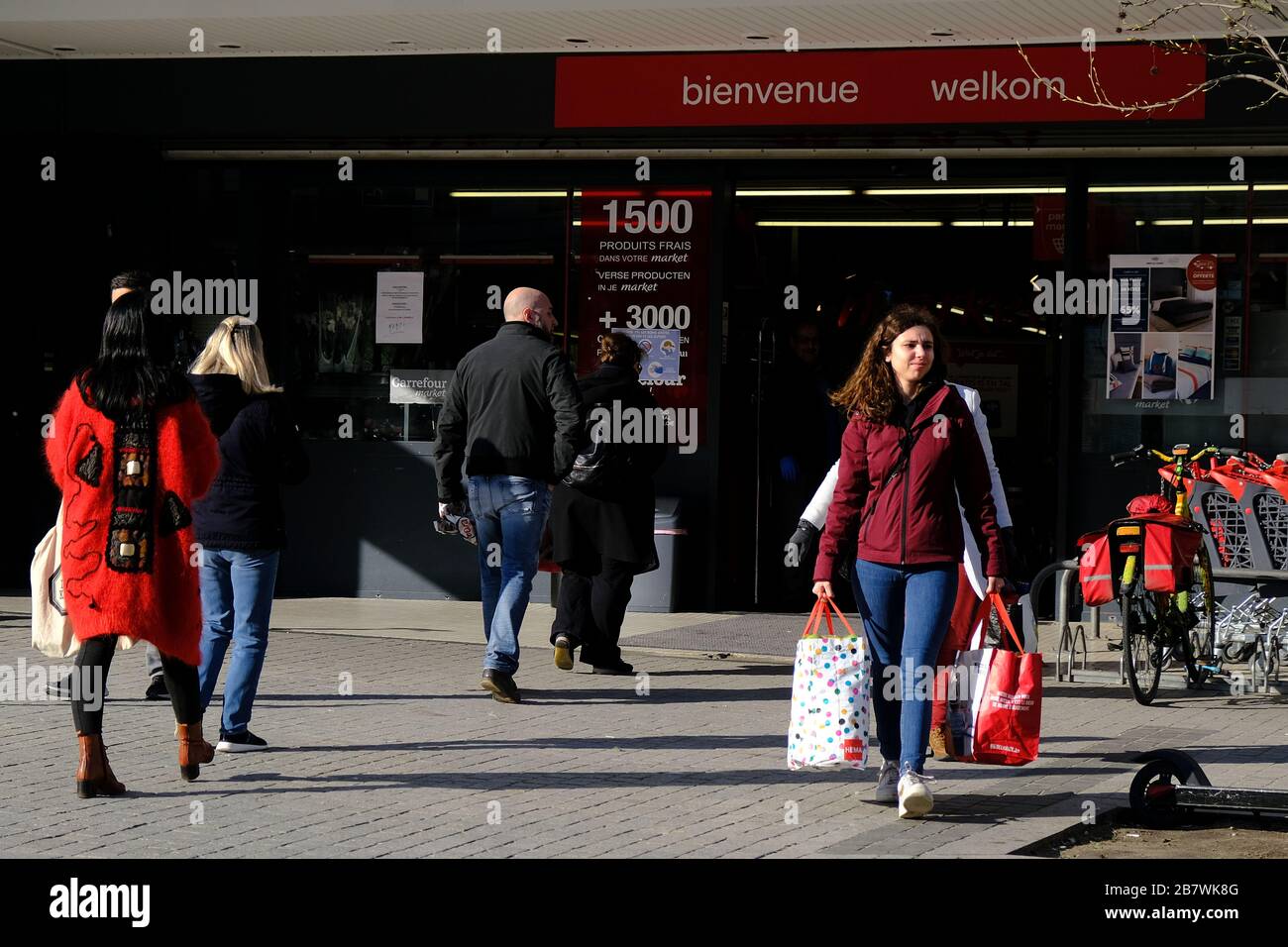 Bruxelles, Belgio. 18 Marzo 2020. Gli acquirenti si trovano in coda al di fuori di un supermercato prima che il governo belga imponga un blocco di coronavirus. Credit: ALEXANDROS MICHAILIDIS/Alamy Live News Foto Stock