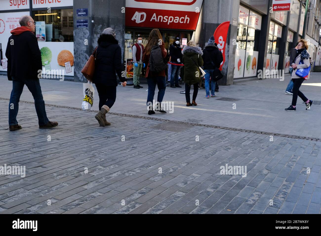 Bruxelles, Belgio. 18 Marzo 2020. Gli acquirenti si trovano in coda al di fuori di un supermercato prima che il governo belga imponga un blocco di coronavirus. Credit: ALEXANDROS MICHAILIDIS/Alamy Live News Foto Stock
