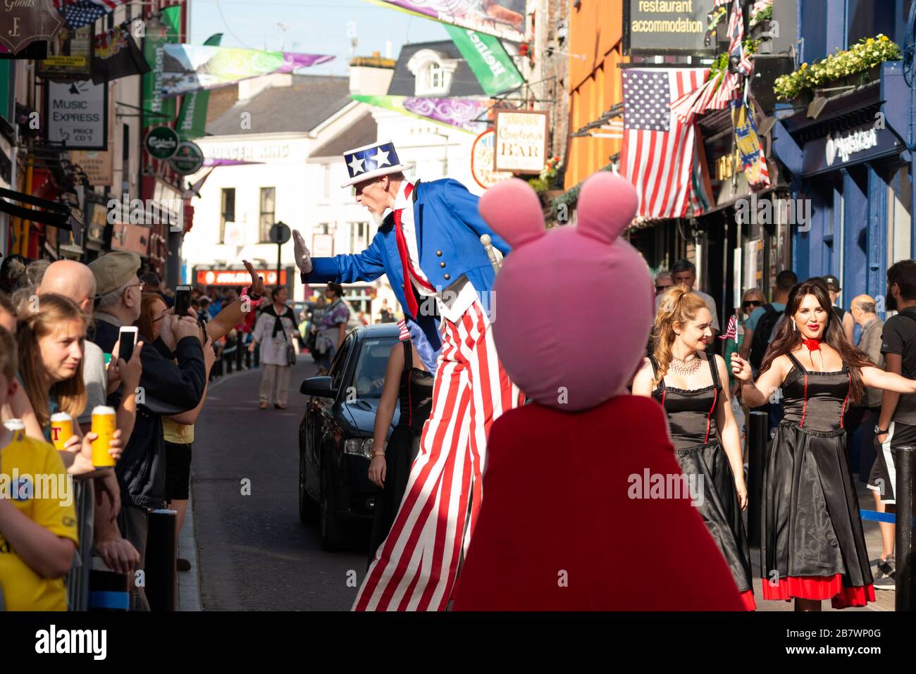 Zio Sam Street performer e le persone per le strade durante il 4 luglio Independence Day Parade e celebrazioni a Killarney, County Kerry, Irlanda Foto Stock