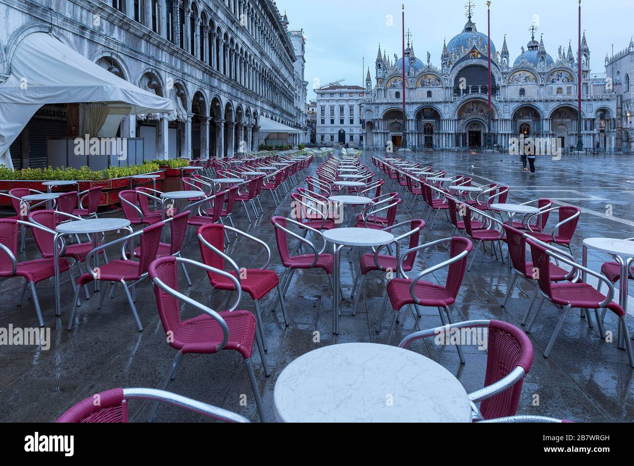 Piazza San Marco vuota con portici della vecchia procura, XVI secolo e la Cattedrale di San Marco in prima mattinata in tempo piovoso, Venezia Foto Stock