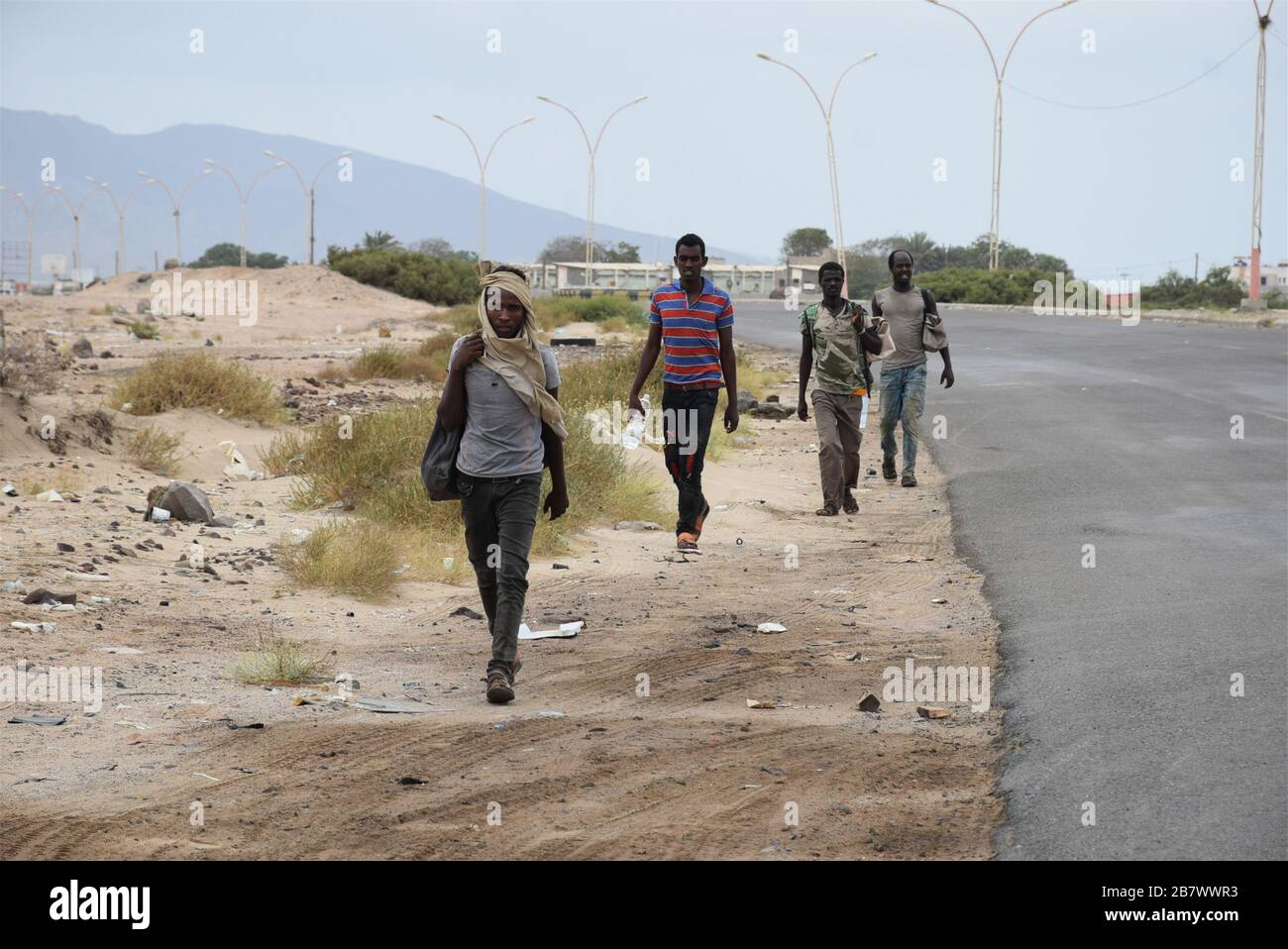 Aden, Yemen. 18 Marzo 2020. Gli immigrati africani sono visti dirigersi verso la periferia occidentale della città portuale meridionale di Aden, Yemen, 18 marzo 2020. Il governo dello Yemen ha dichiarato una serie di misure precauzionali nel tentativo di frenare lo scoppio del coronavirus nel paese arabo devastato dalla guerra. Nonostante queste misure, lo Yemenita ha detto che migliaia di immigrati africani e richiedenti asilo continuano a rifugiarsi nel paese attraverso i valichi di frontiera illegali, poiché l'autorità sui valichi di terra, aria e mare dello Yemen è fratturata tra il governo Saudita e l'Iani Credit: Xinhua/A. Foto Stock