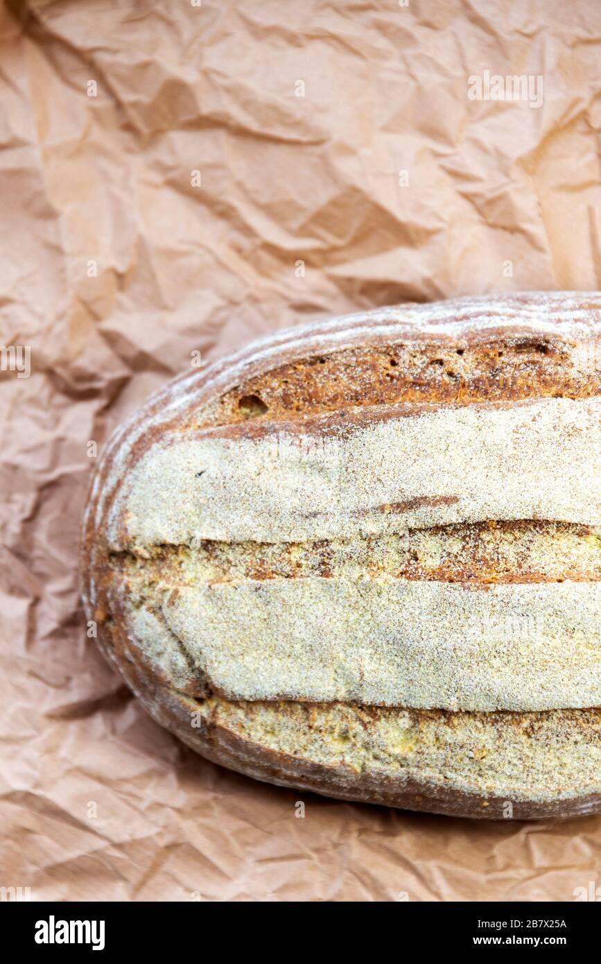 Pane in stile casale fatto in casa, fresco fuori il forno su un foglio di carta marrone Foto Stock