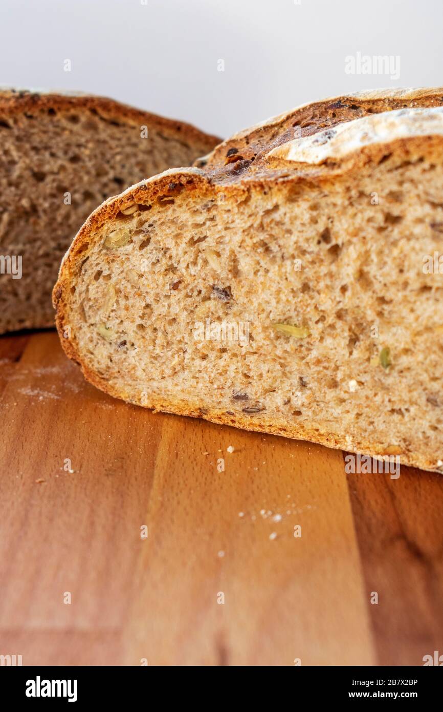 Pane di pane appena sfornato tagliato a metà per svelare i chicchi all'interno Foto Stock