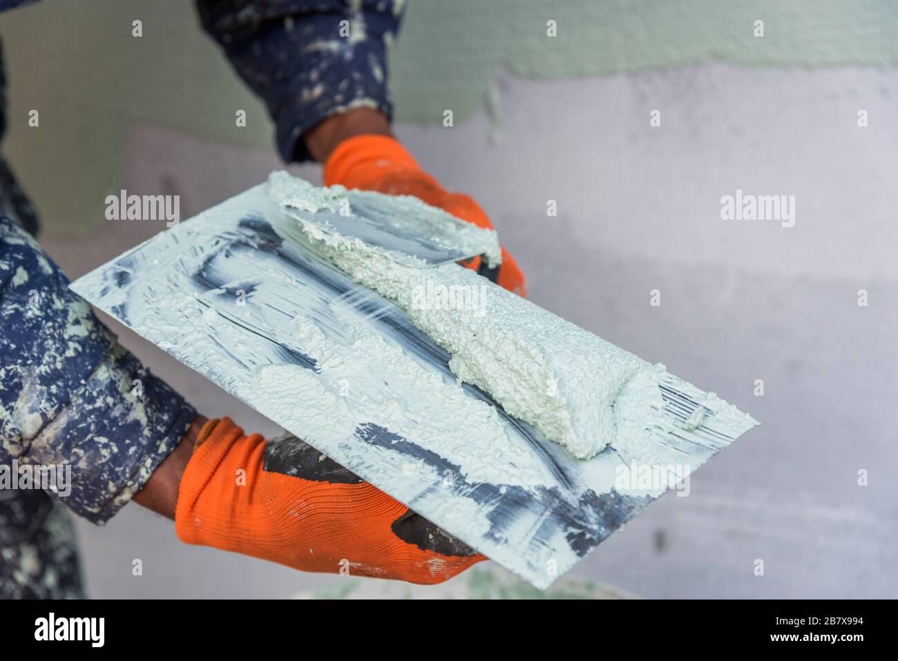 Applicazione di lastre per facciate, intonacatura della facciata dell'edificio, primo piano. Foto Stock