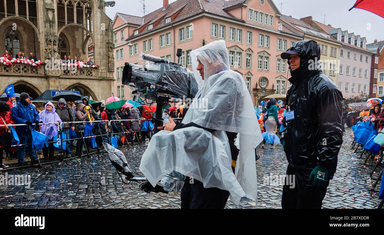 Braunschweig, Germania, 23 febbraio 2020: Squadra di una stazione televisiva con attrezzatura fotografica impermeabile imballata durante le registrazioni video della carniva Foto Stock