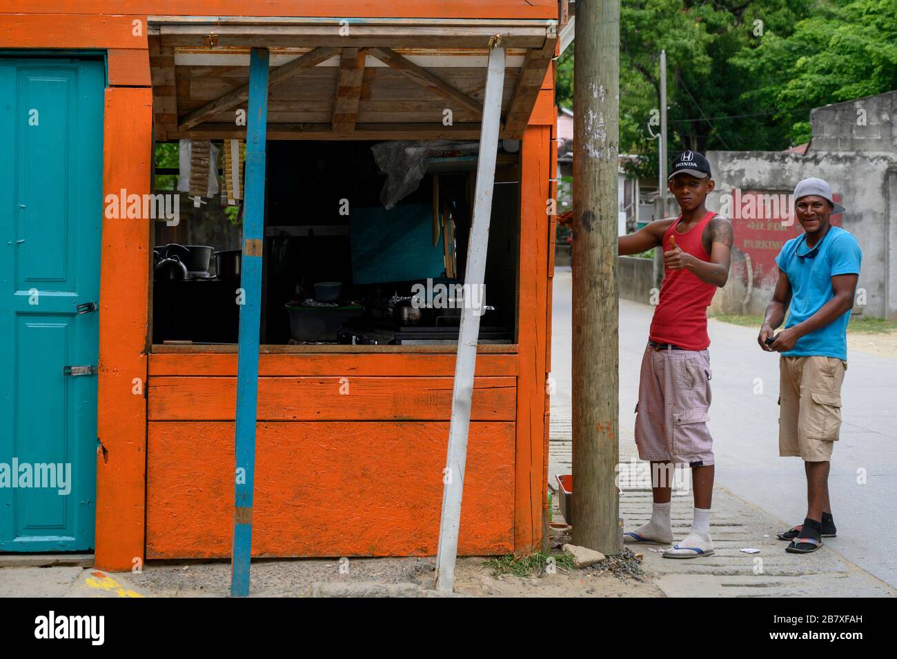 Due uomini in piedi fuori negozio, Coxen Hole, Ghiel Bay, Honduras Foto Stock