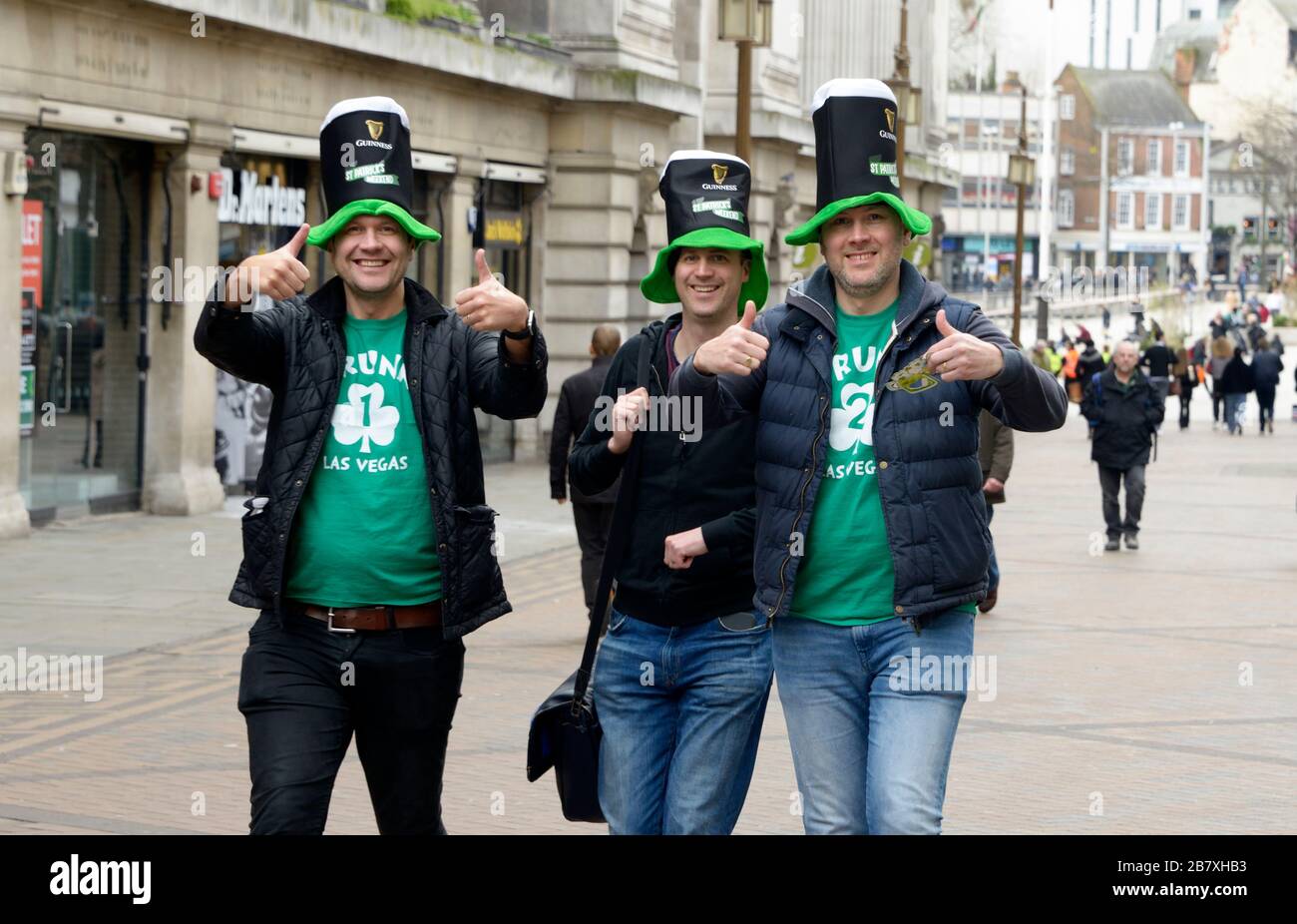 Tre ragazzi fuori in città, celebrando il giorno di San Patrizio, con i cappelli Guinness, a Nottingham. Foto Stock