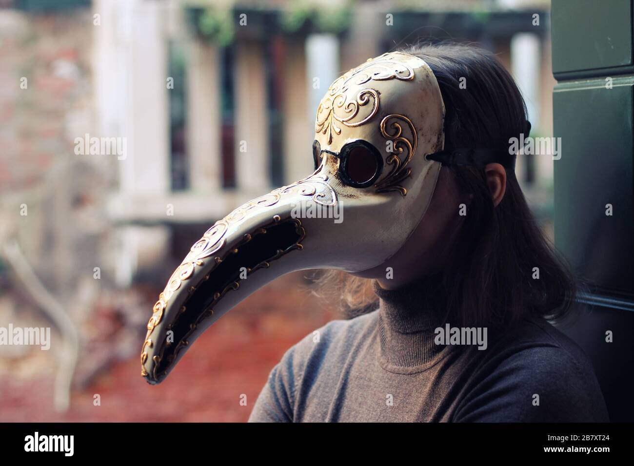 Giovane donna in veneziano fatto a mano peste medico maschera primo piano. Venezia, Italia. Foto Stock