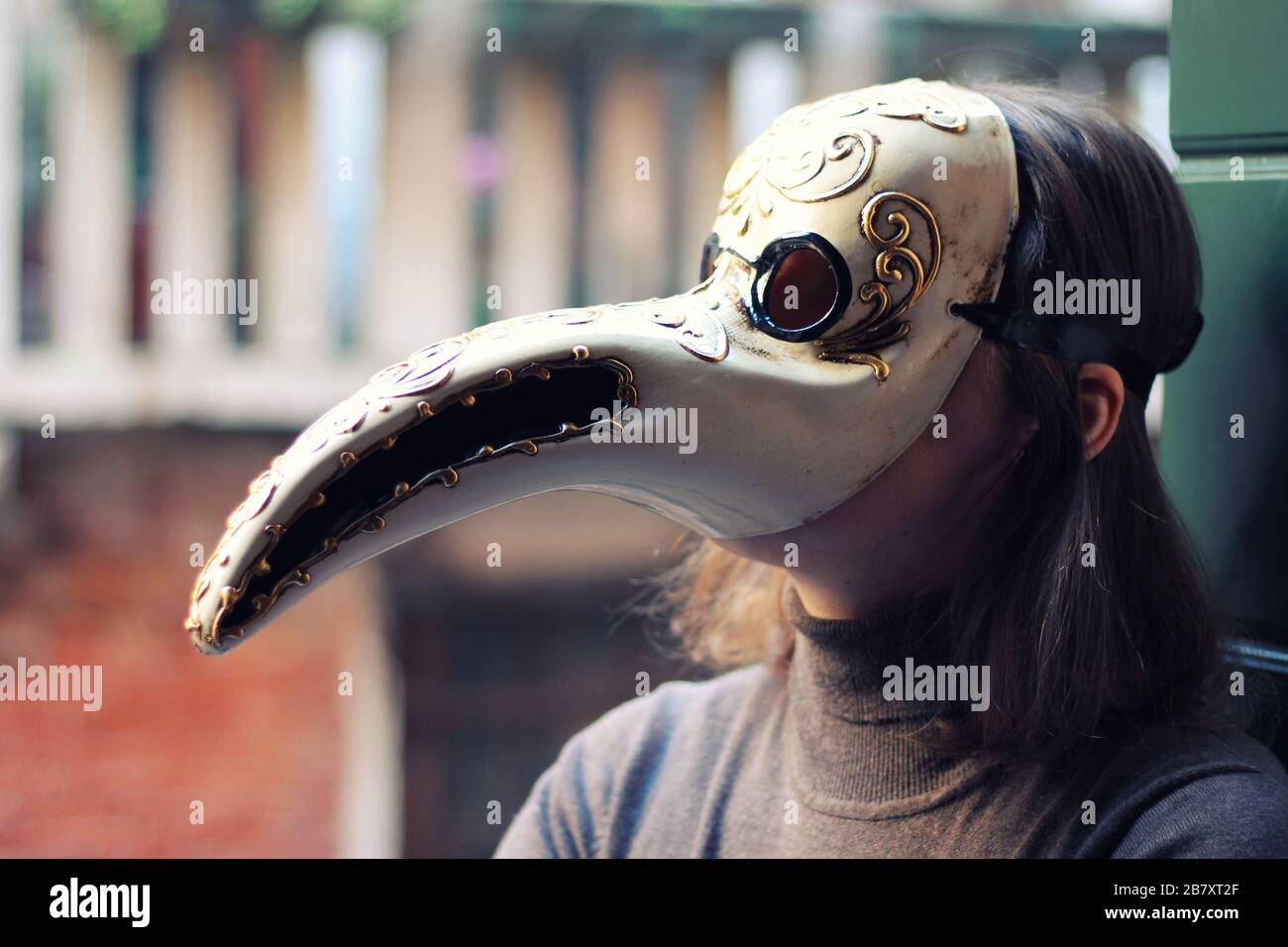 Giovane donna in veneziano fatto a mano peste medico maschera primo piano. Venezia, Italia. Foto Stock
