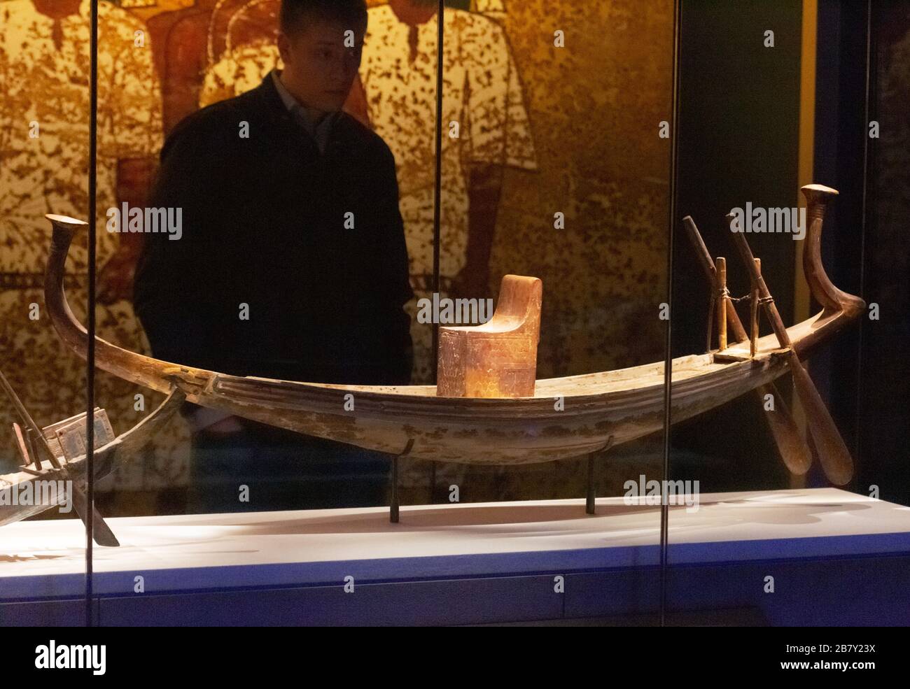 Un visitatore della mostra Tutankhamun che guarda un modello di barca solare dalla tomba di Tutankhamen, dall'Antico Egitto; Saatchi Gallery London UK Foto Stock