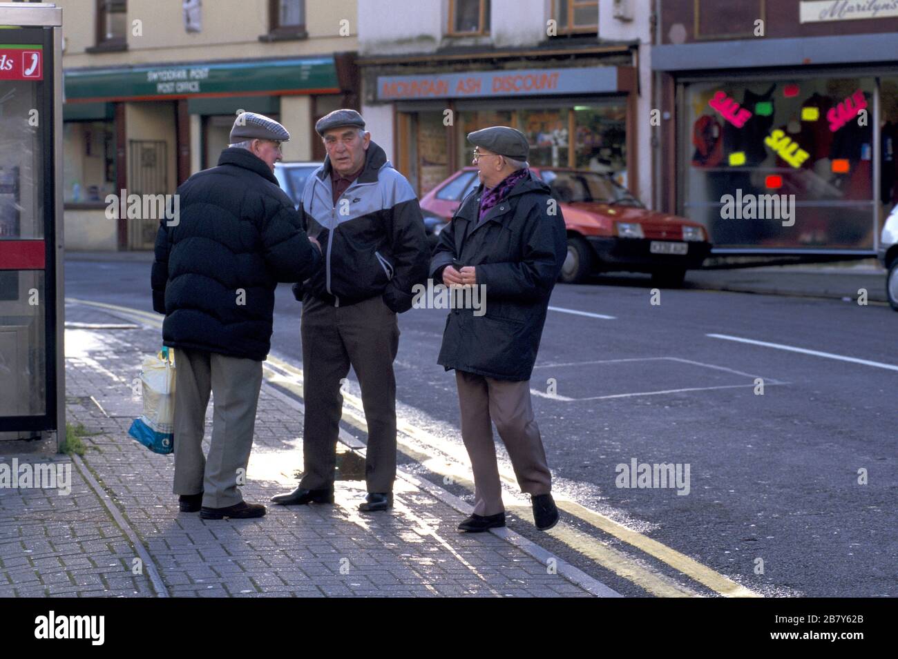 'Mountain Ash, Glamorgan, Galles anni '90 disoccupati uomini che vivono su prestazioni, gruppo di parlare per strada. 1998 OMERO SYKES Foto Stock