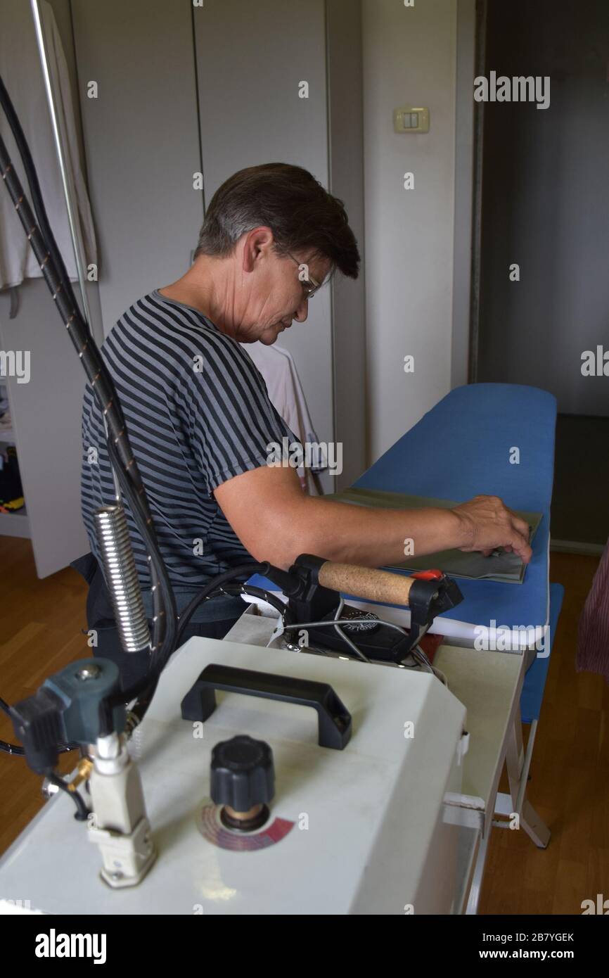 Donna lavorata, lavanderia da stiro Foto Stock